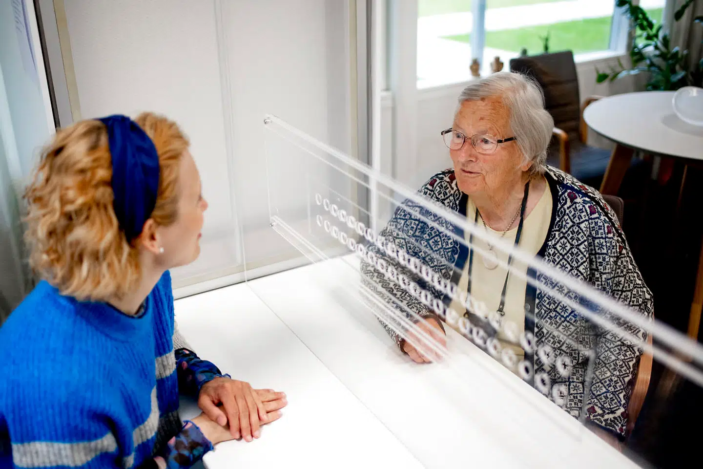 Arkivfoto. Tornbjerg Friplejehjem har fået en samtaleboks, som sikrer beboerne mod coronasmitte, når de har besøg. Beboer Agnethe »Nete« Thomsen og forstander Christine Wille afprøver boksen. Nu skal en aftale til 165 millioner kroner sikre at alle plejehjem kan lave løsninger, så beboerne kan se deres pårørende.