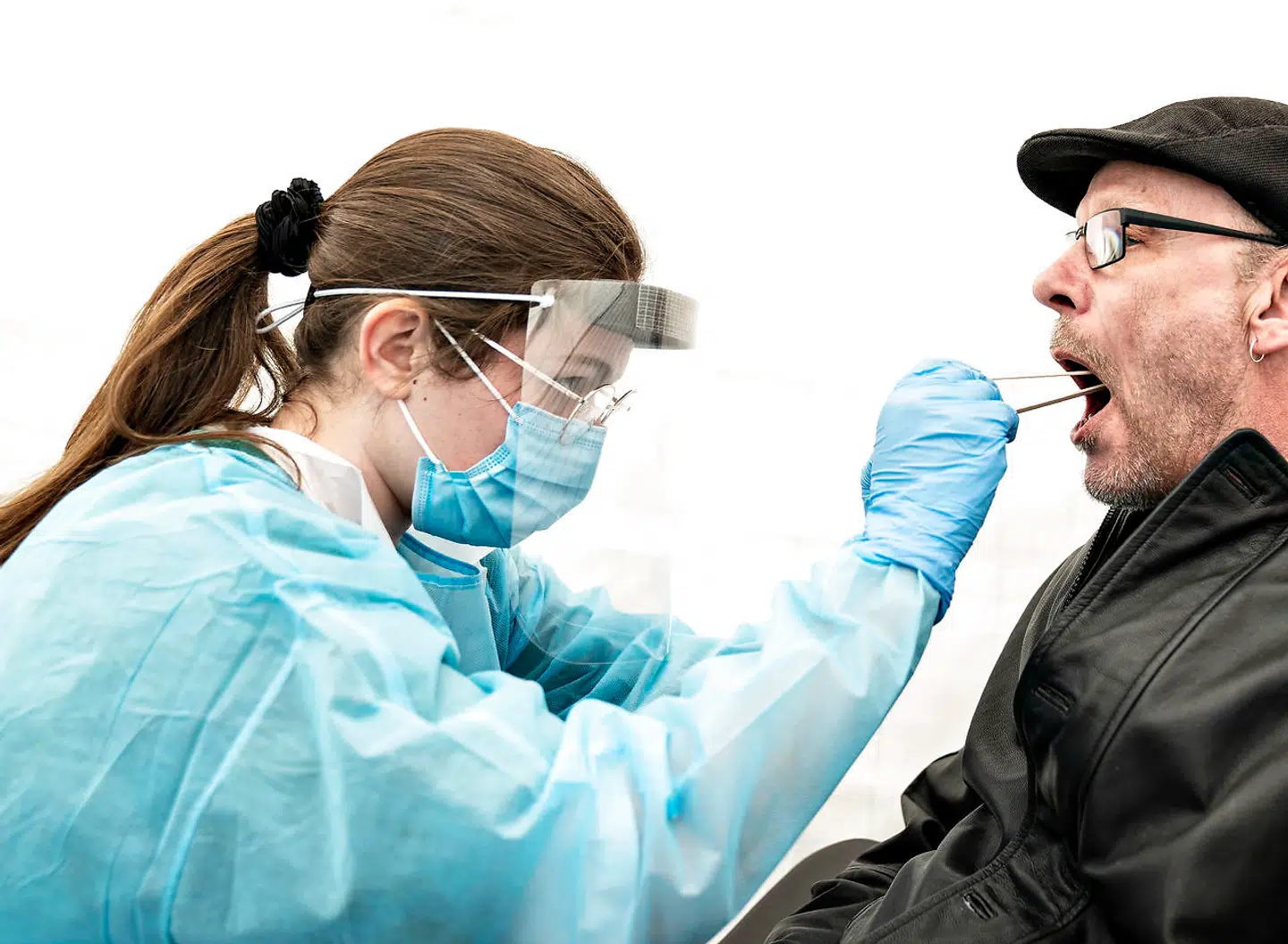 »Den udvidede strategi om massetest og kontaktopsporing lyder på papiret god og betryggende. Men begge tiltag rejser bekymringer hos os, der står med patienterne til dagligt,« skriver lægerne Jens Lundgren, Lars Jørgen Østergaard og Ida Donkin. Arkivfoto af en sundhedsmedarbejder, der tager en test på en person i det nye testcenter i telte på Aalborg Kaserner.