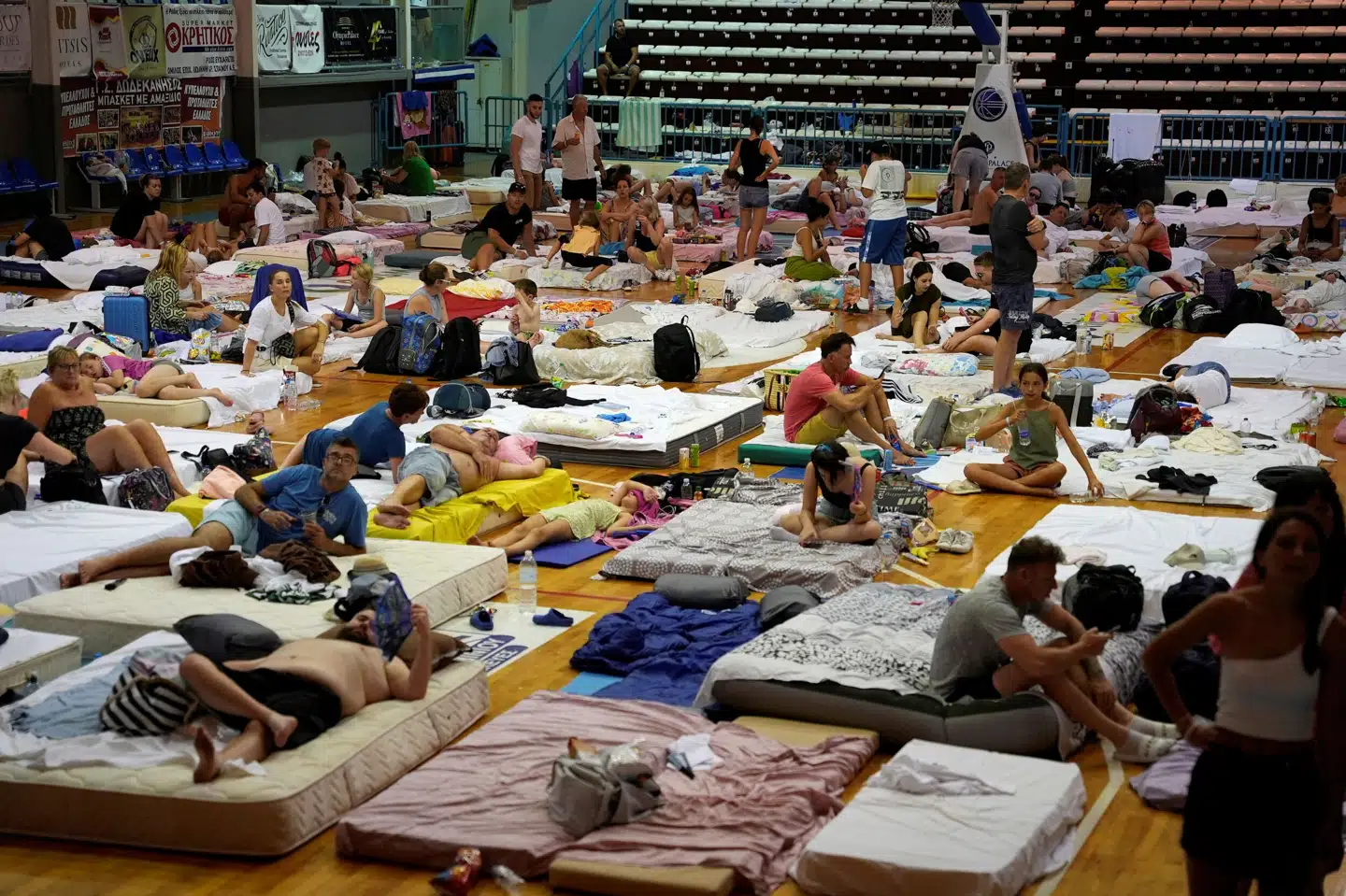 Evakuerede turister ses her i en sportshal søndag. Fedja Grulovic/Reuters