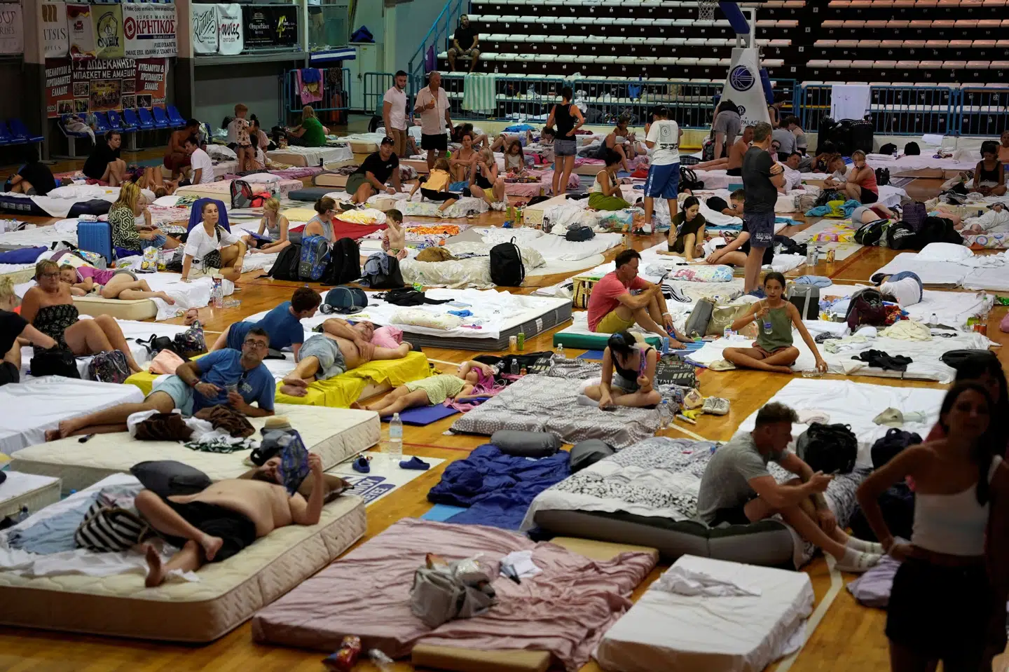 Evakuerede turister ses her i en sportshal søndag. Fedja Grulovic/Reuters