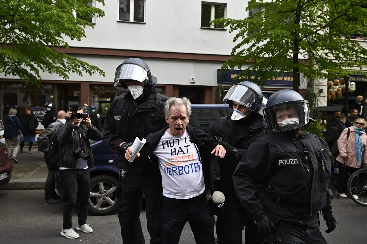 Politifolk i Berlin forsøger at fjerne en af de mange demonstranter, som lørdag deltog i protester mod regeringens restriktioner for at bremse coronasmitten. Tobias Schwarz/Ritzau Scanpix