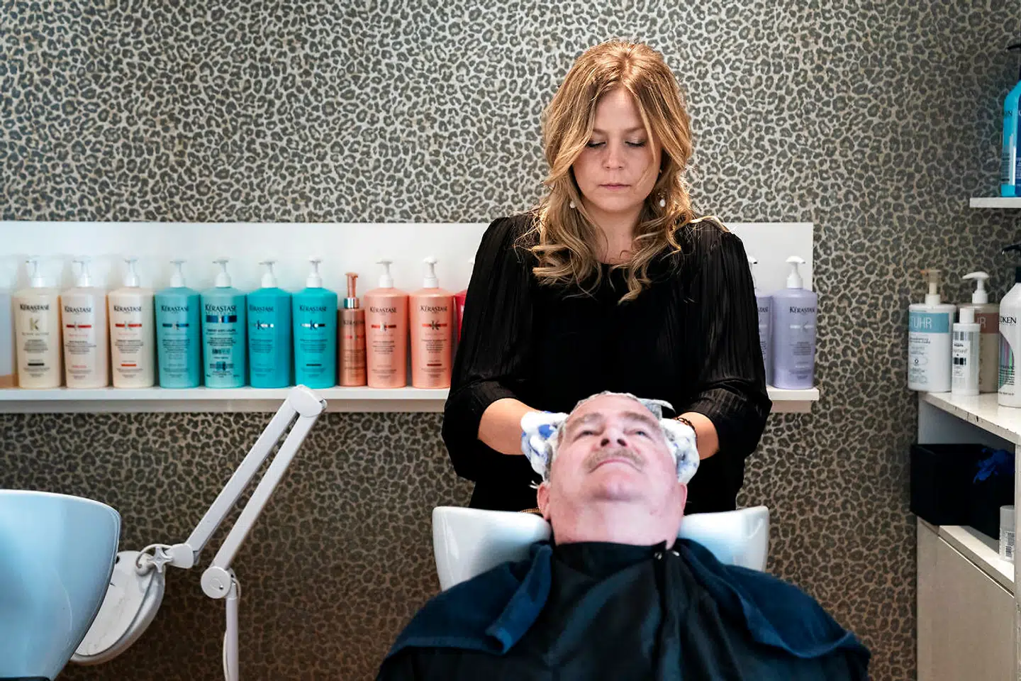 Nadia Hansen vasker Thomas Højlunds hår, før han skal klippes.