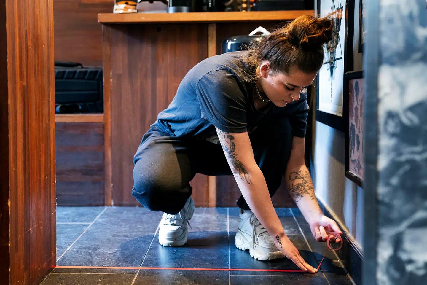 Olivia Johanne Alice Rosendal Johannessen gør Miks Tattoo klar til genåbning ved at sætte en afstandslinje op i venterummet.