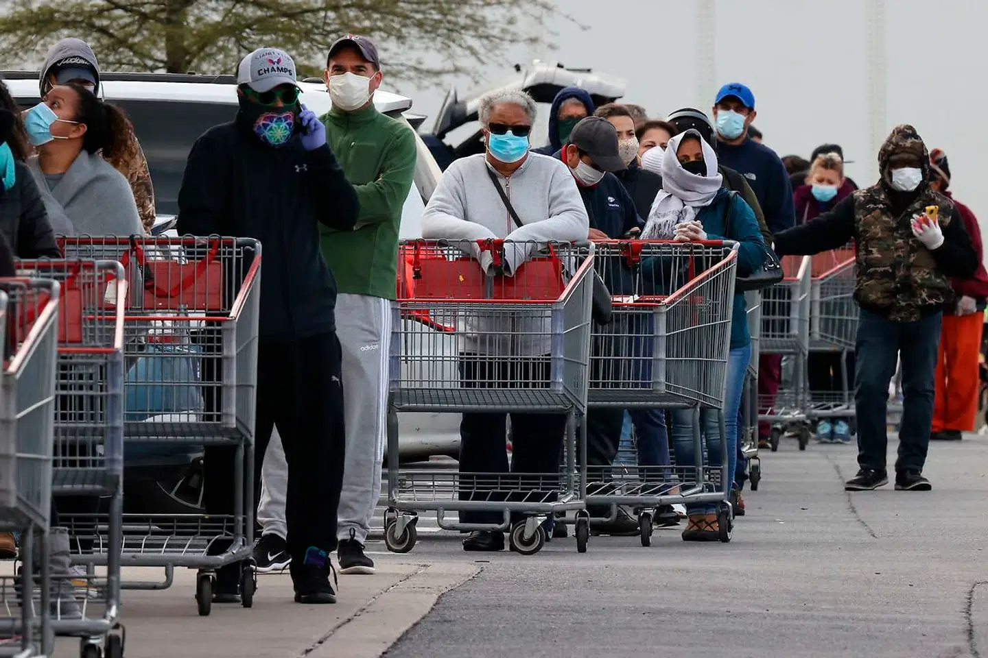 Kunder i kø med ansigtsmasker uden for supermarkeds-engroskæden Costco i Maryland - en af de stater hvor guvernøren har pålagt folk at bære masker, når de handler. Chip Somodevilla/Getty Images/AFP == FOR NEWSPAPERS, INTERNET, TELCOS & TELEVISION USE ONLY ==