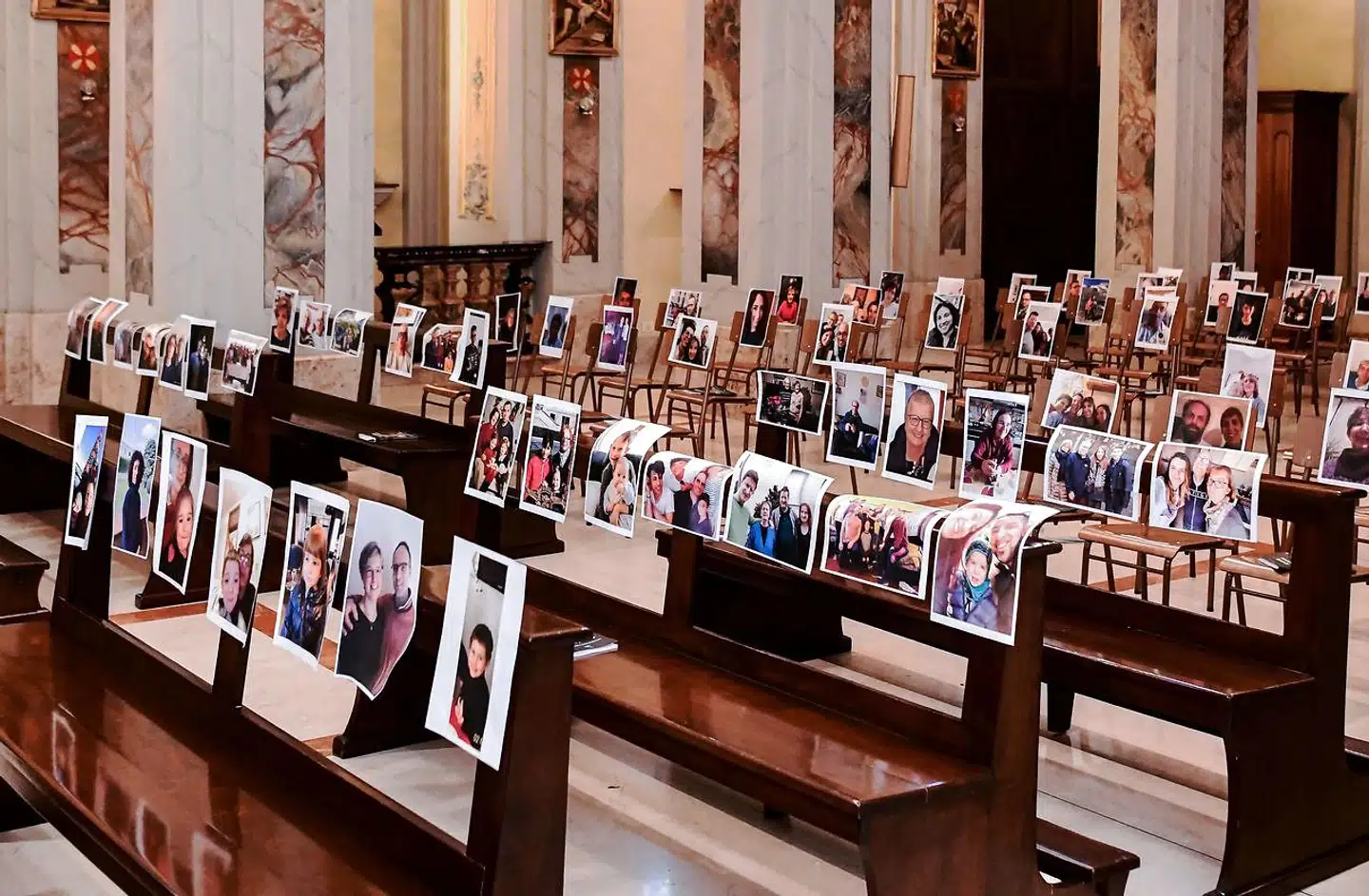 This picture taken on March 22, 2020 shows the empty Church of Robbiano, during the Sunday mass with selfie photographs sent to Don Giuseppe Corbari parson of the church, by his congregation members and glued to empty pews in Giussano on March 22, 2020. - Italian Prime Minister Giuseppe Conte on March 21 ordered all non-essential companies and factories to close nationwide to stem a coronavirus pandemic that has killed 4, 825 people in the country in a month. "The decision taken by the government is to close down all productive activity throughout the territory that is not strictly necessary, crucial, indispensable, to guarantee us essential goods and services, " Conte said in a late-night TV address (Photo by Piero CRUCIATTI / AFP)