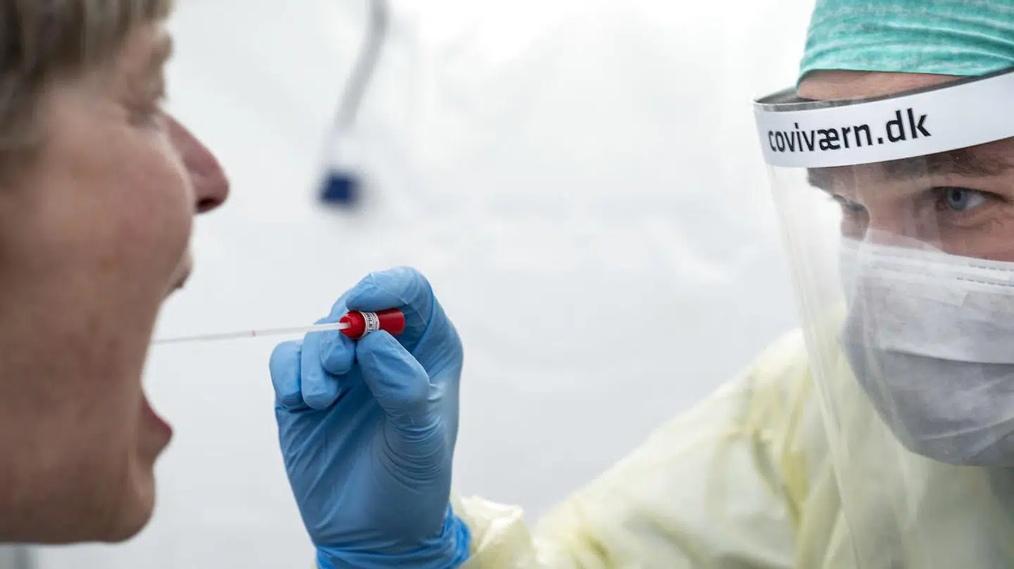 En læge fra Rigshospitalet poder en patient for coronasmitte iført forklæde, handsker, mundbind og visir for ikke selv at blive smittet under sit arbejde. Visiret er produceret i Danmark af en skiltevirksomhed, som har omlagt produktionen.