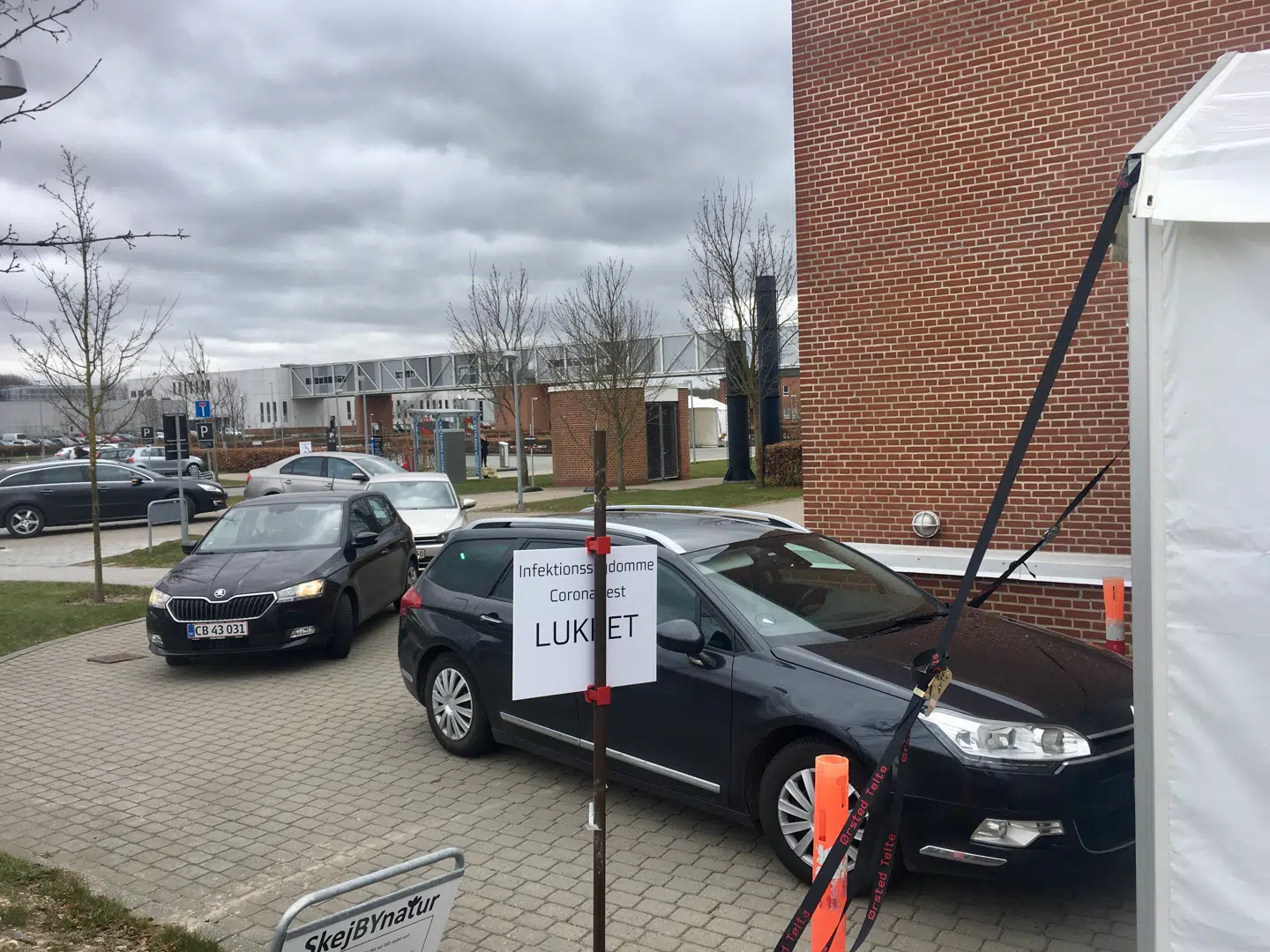 Ved Aarhus Universitetshospital har der hele dagen været biler i kø til det hvide telt på parkeringspladsen, hvor borgere kan blive testet for covid-19.