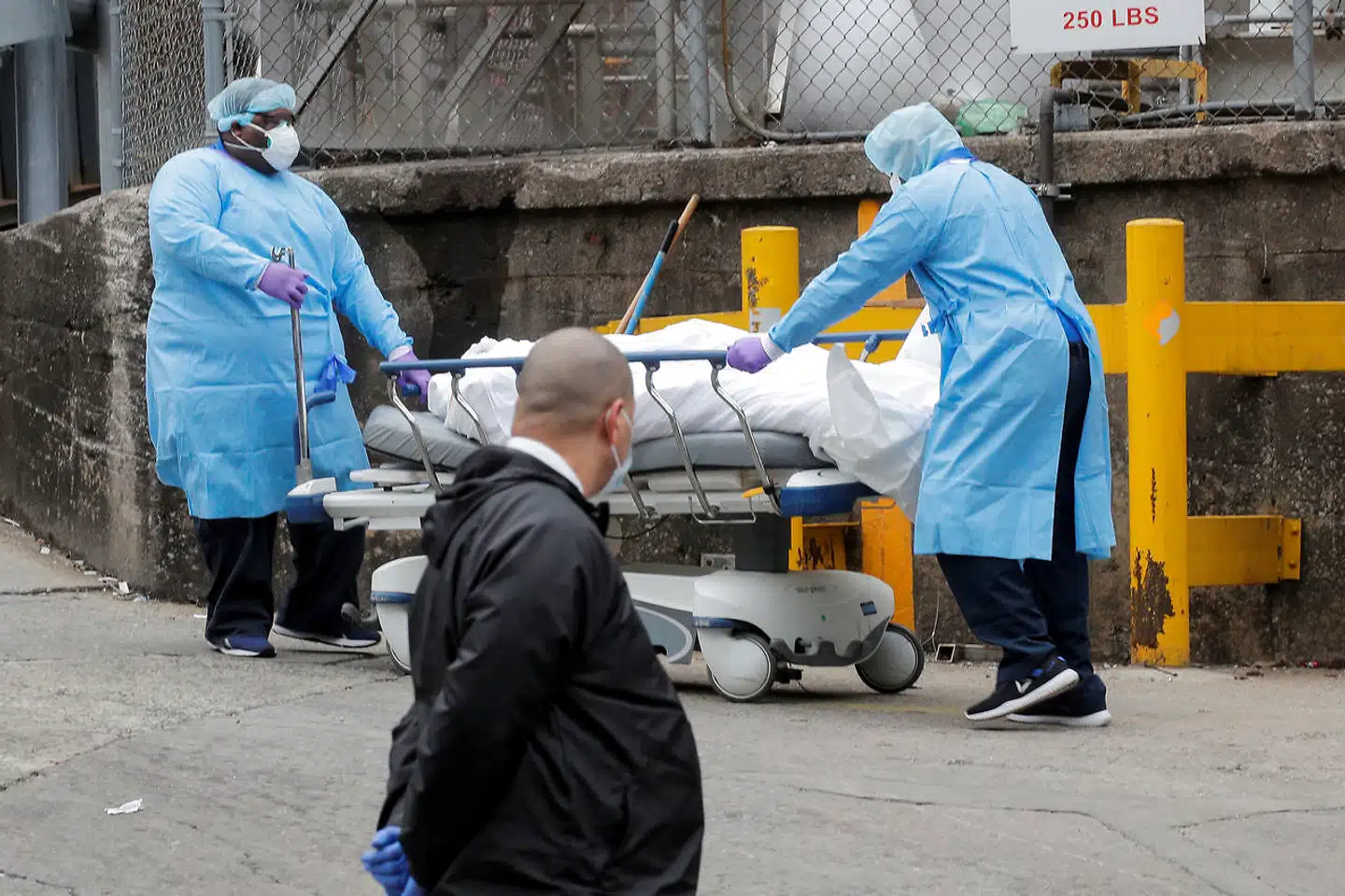 Sundhedsarbejdere kører en afdød covid19-patient væk uden for Brooklyn Hospital Center i New York.