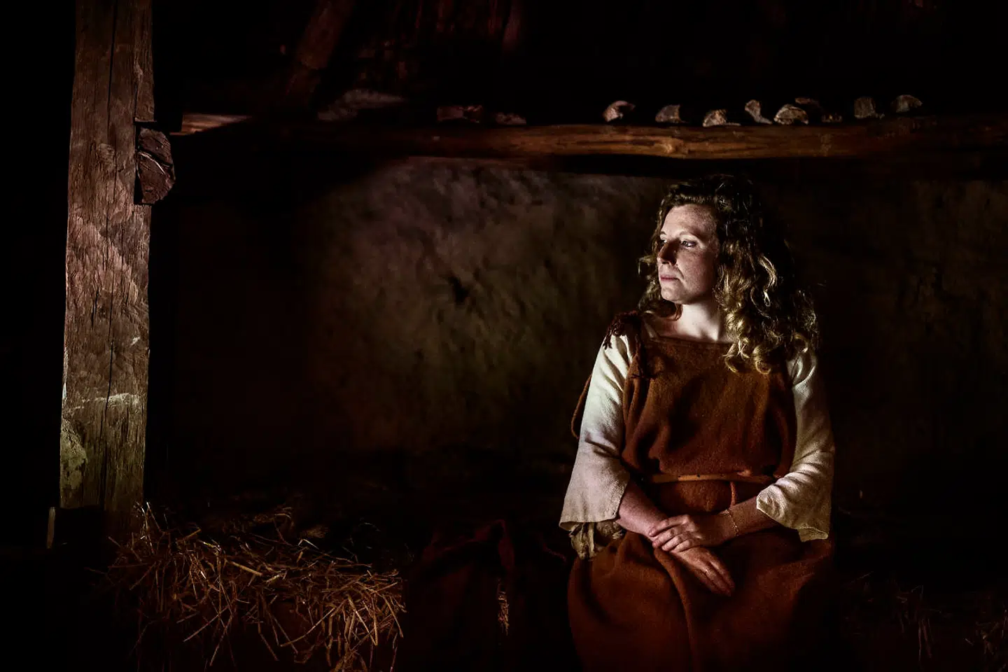 »Jeg tænker på, at hvis smitten bliver ved med at sprede sig, kan vi flytte længere ind i naturen, min datter og jeg. Der er et sted i skoven, langt inde ved en lille lysning, hvor vi engang byggede en hule,« skriver Dy Plambeck – her fotograferet i en hytte i Jernalderbyen i Lejre i 2015.