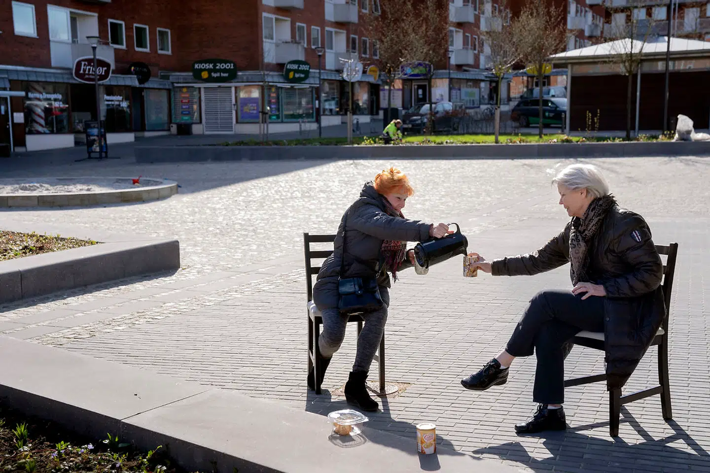 Bente på 80 år har klunset et par stole fra storskrald og mødes med veninderne på torvet i Søborg. Her har hun besøg af Jytte på 79 år til en kop kaffe i behørig afstand.