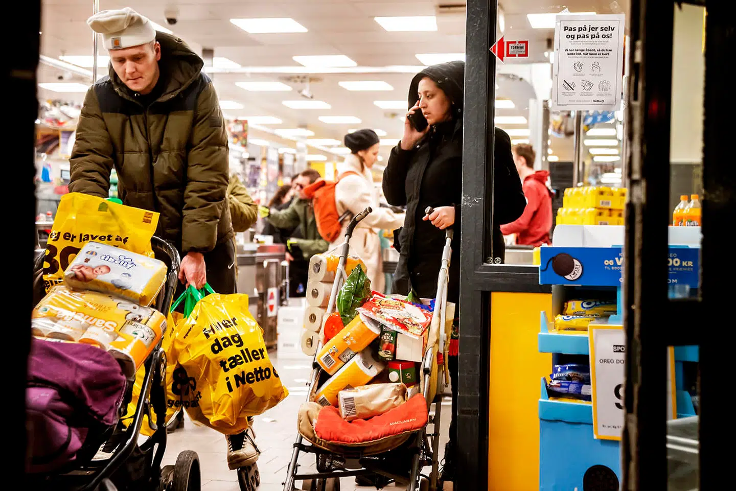 Kunder forlader Netto på Vesterbro med fyldte indkøbsposer onsdag den 11. marts, få timer efter at regeringen har meddelt, at Danmark er på vej til at lukke ned på grund af coronaudbrud.