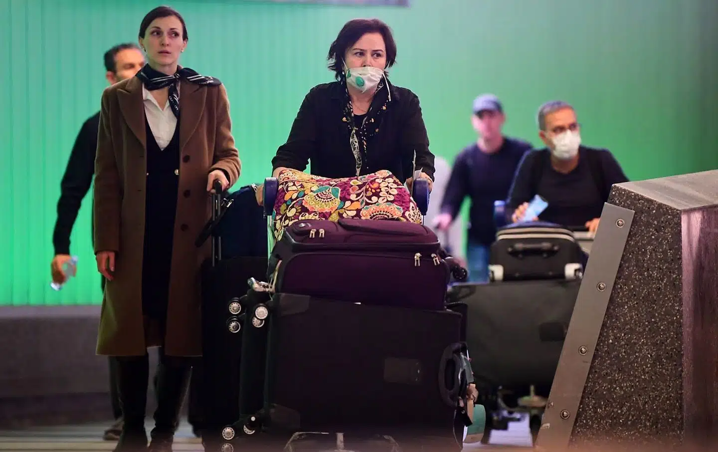Internationale rejsende med ansigstmasker ankommer til Los Angeles International Airport torsdag, dagen før indrejseforbuddet fra 26 europæiske lande træder i kraft.