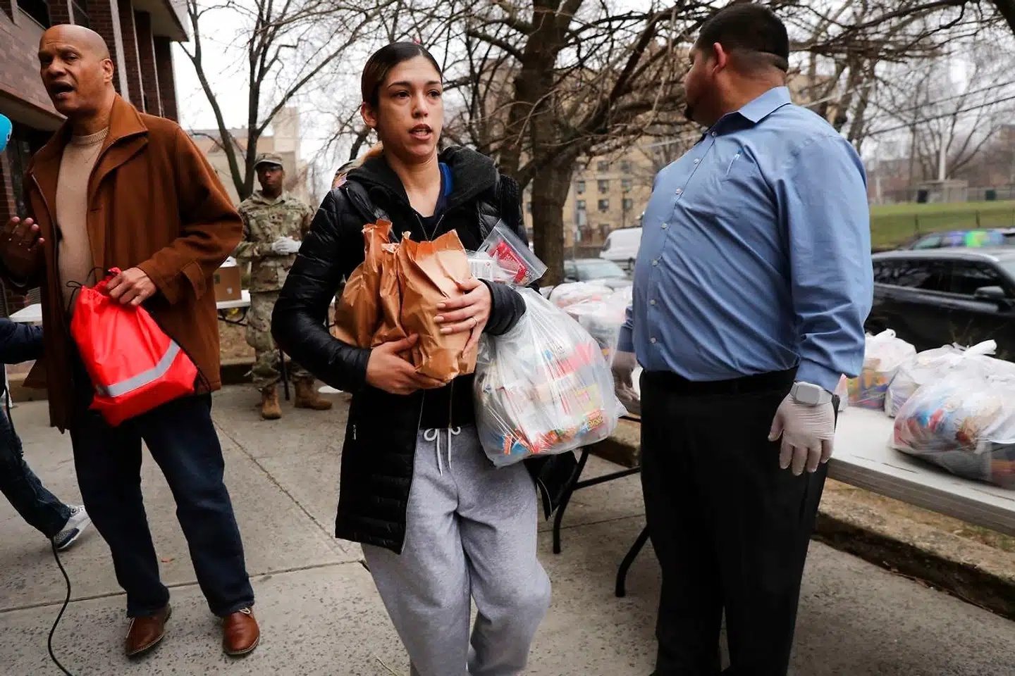 Beboere modtager poser med mad fra Nationalgarden i nærheden af New Rochelle lige nord for New York City. New Rochelle er blevet delstatens største kilde til coronavirus, og derfor har guvernøren beordret hegn omkring det område, hvor antallet af smittede stiger hurtigst.
