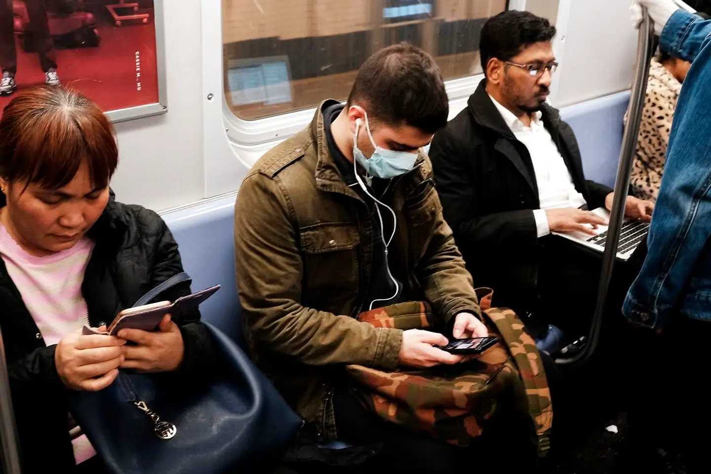 Panikken begynder at brede sig i New York. Her er en passager, der bærer maske i byens subway for at beskytte sig imod coronavirus.