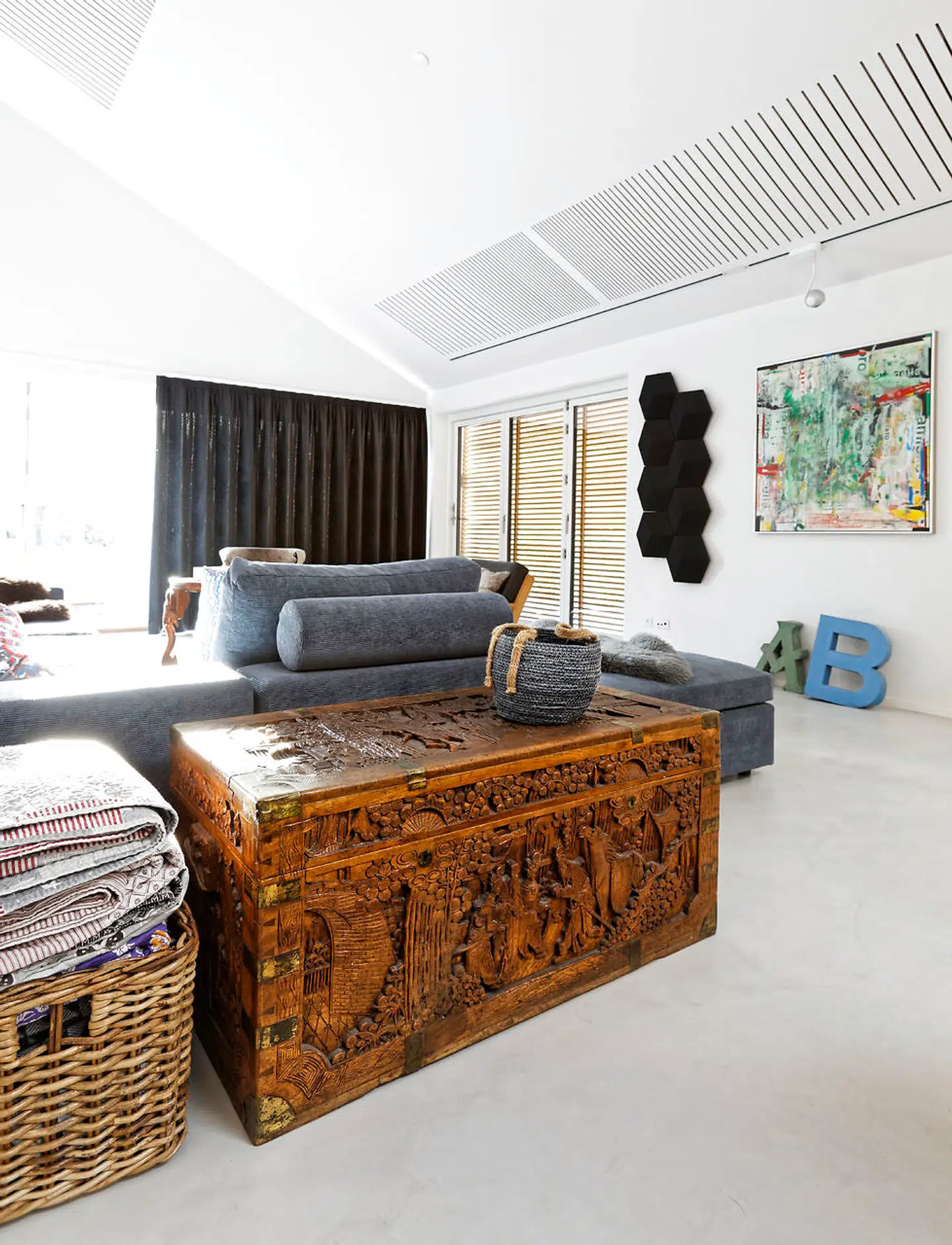 Akustiklofter, fløjlsgardiner og B&O højttalerpanel blødgør lyden i huset med fiberbetongulve. Den antikke kamferkiste er over 100 år gammel og hjembragt af Anne Robertsens morfar, som sejlede for ØK.