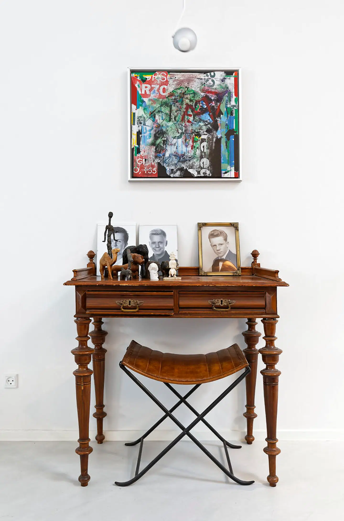 På det arvede, antikke rygebord står portrætter af sønnerne og svigerfar som ung. Figurerne er blandt andet grønlandske tupilakker, Brian Robertsen har haft med hjem fra Grønland, hvor han indretter butikker.