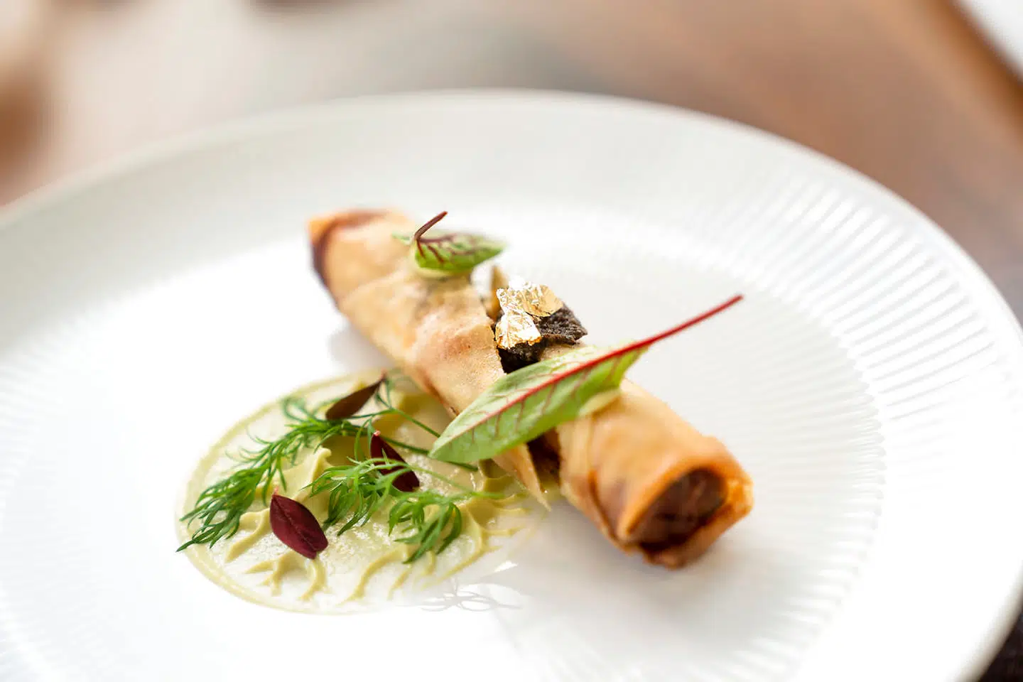En forårsrulle fyldt med rejer, forårsløg og shiitakesvampe lå på et grønt »stilke«-mønster af avocadocreme, smagt til med den japanske citrusfrugt yuzu.