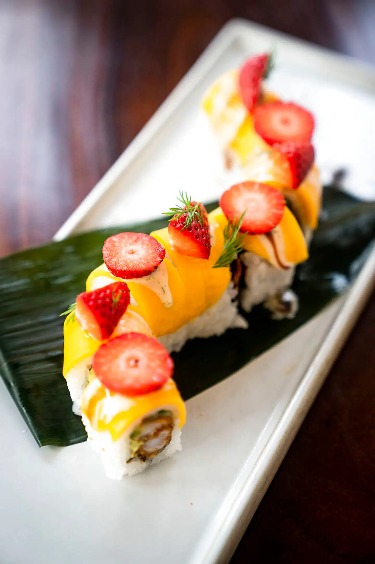 Happy Together, en omvendt rullet maki med risen yderst og fyld af tynde agurkestave og en tempuradybstegt reje pakket farverigt ind i gul mango og jordbær.