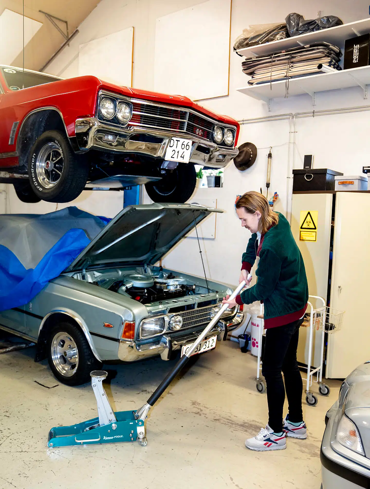 Livet med klassiker og youngtimer er ofte en balancegang, hvor der skal findes plads til både kørsel og mekanisk omsorg. Den røde bil, der hænger på liften, tilhører Frederiks hustru. Der er tale om en Buick Skylark GS fra 1966 med 6,6 liters Big Block-V8er.