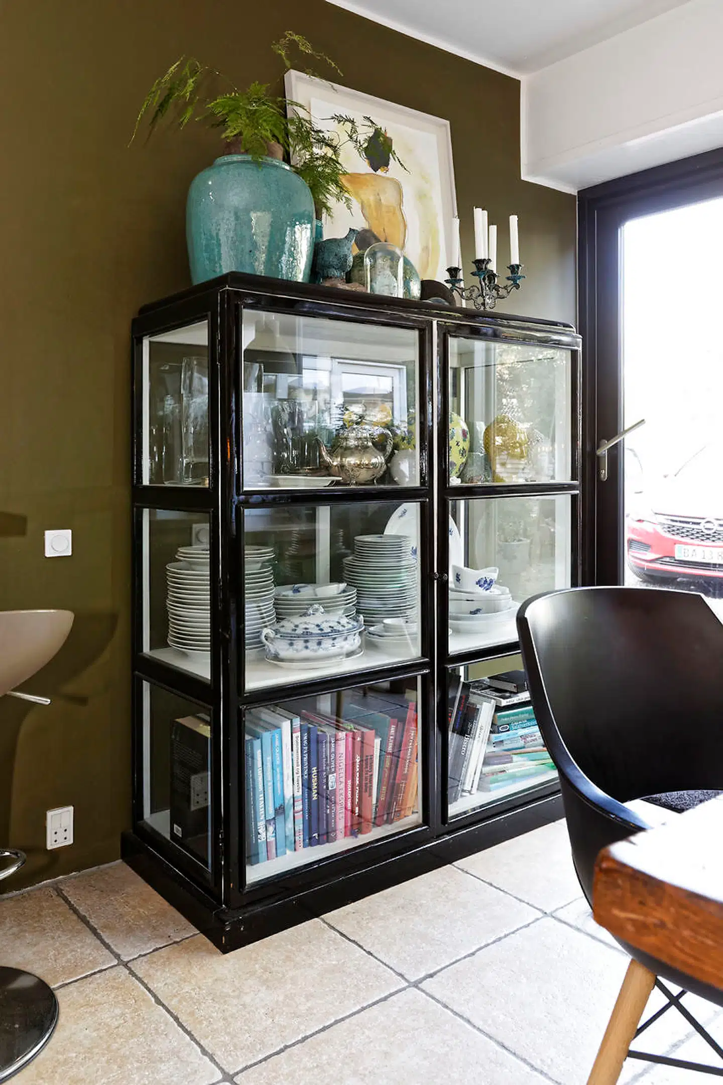 Majbritt Ingemann er hurtig til at få malet sine yndlingsfarver som her olivengrøn fra Flügger på køkkenvæggen med det sorte vitrineskab fra Hübsch.