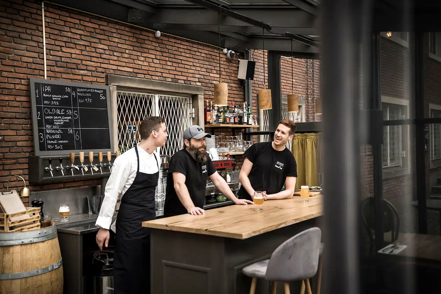 Lasse Philipsen (th) står sammen med Claus Hastrup (midtfor) bag Frederiksberg Bryghus, som i fem år har brygget øl i kælderen under Frederiksberg Rådhus. Her i den nye cocktail- og ølbar ud mod pladsen foran rådhuset. Til venstre ses køkkenchef på Restaurant Frdrksbrg, Asbjørn Ondraschek Jensen.