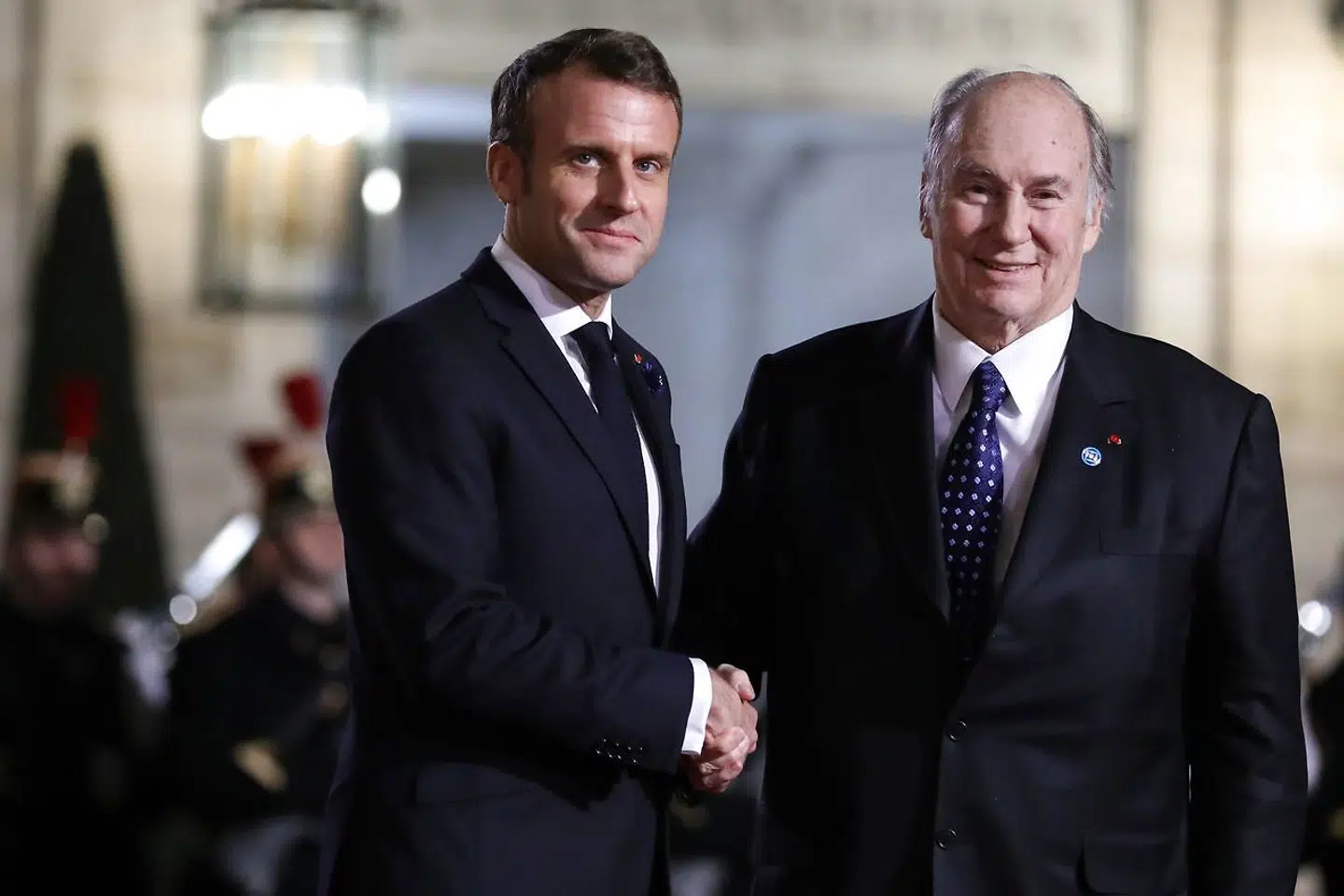 Lederen af den muslimske sekt ismaelitterne, Aga Khan (th.), der her hilser på Frankrigs præsident, Emmanuel Macron, er ikke blot styrtende rig men åbenbart også godtroende. Det benyttede svindlerne sig af.