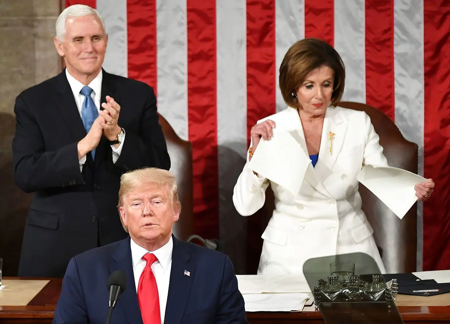 Vicepræsident Mike Pence applauderer Donald Trump, mens lederen af Repræsentanternes Hus, Nancy Pelosi, river en kopi af præsidentens State of The Union-tale i stykker. Foto: Mandel Ngan / Ritzau Scanpix