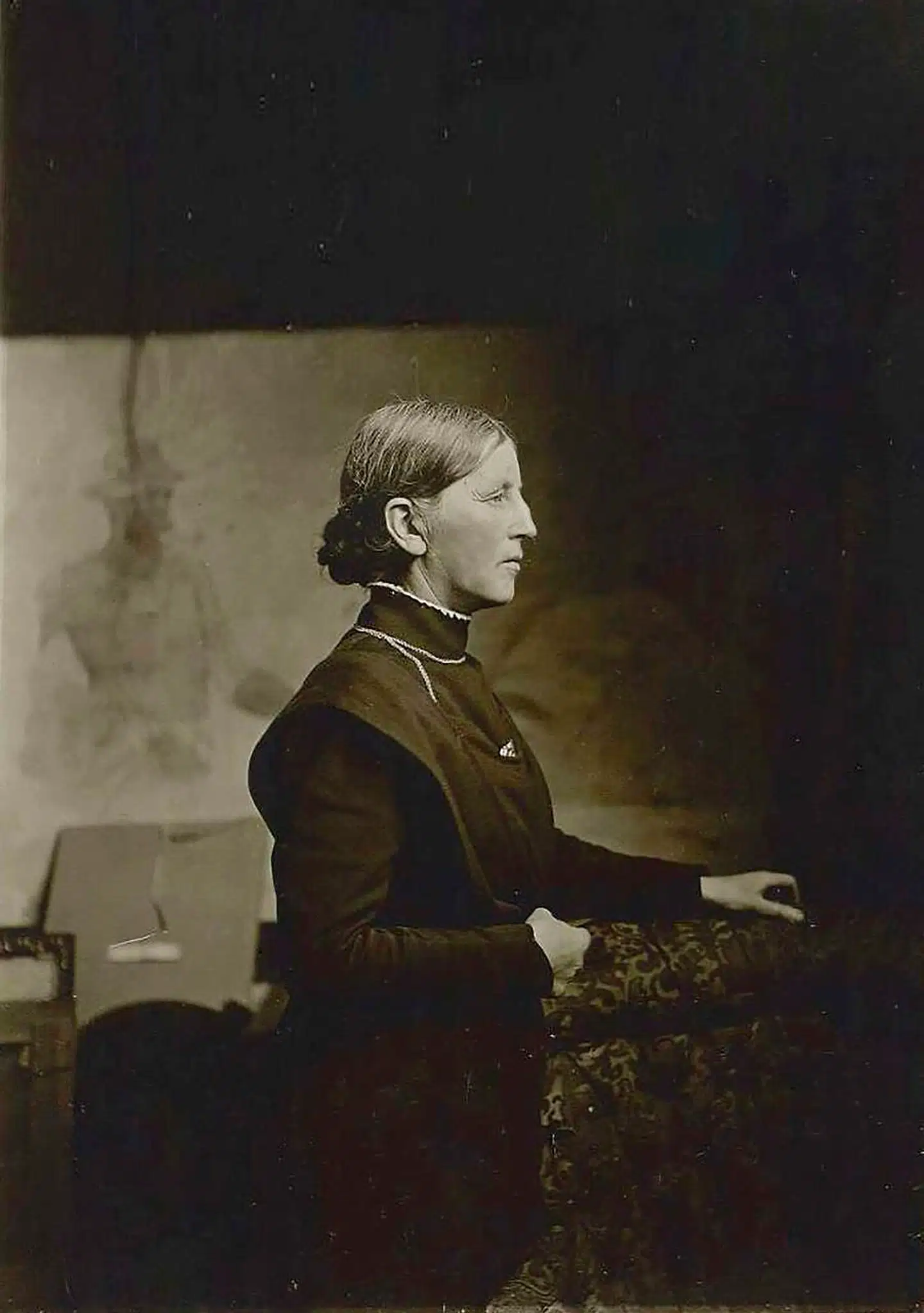 Anna Ancher fotografet i Krøyers atelier i Skagen. Hun voksede op i et indremissionsk miljø i Skagen, hvor hendes forældre drev Brøndums Gæstgiveri. Mødet med kunstnere på gæstgiveriet vakte hendes interesse for kunst. Hun blev gift med Michael Ancher, uddannede sig til kunstner og blev en del af kunstnermiljøet med rejser og fester.