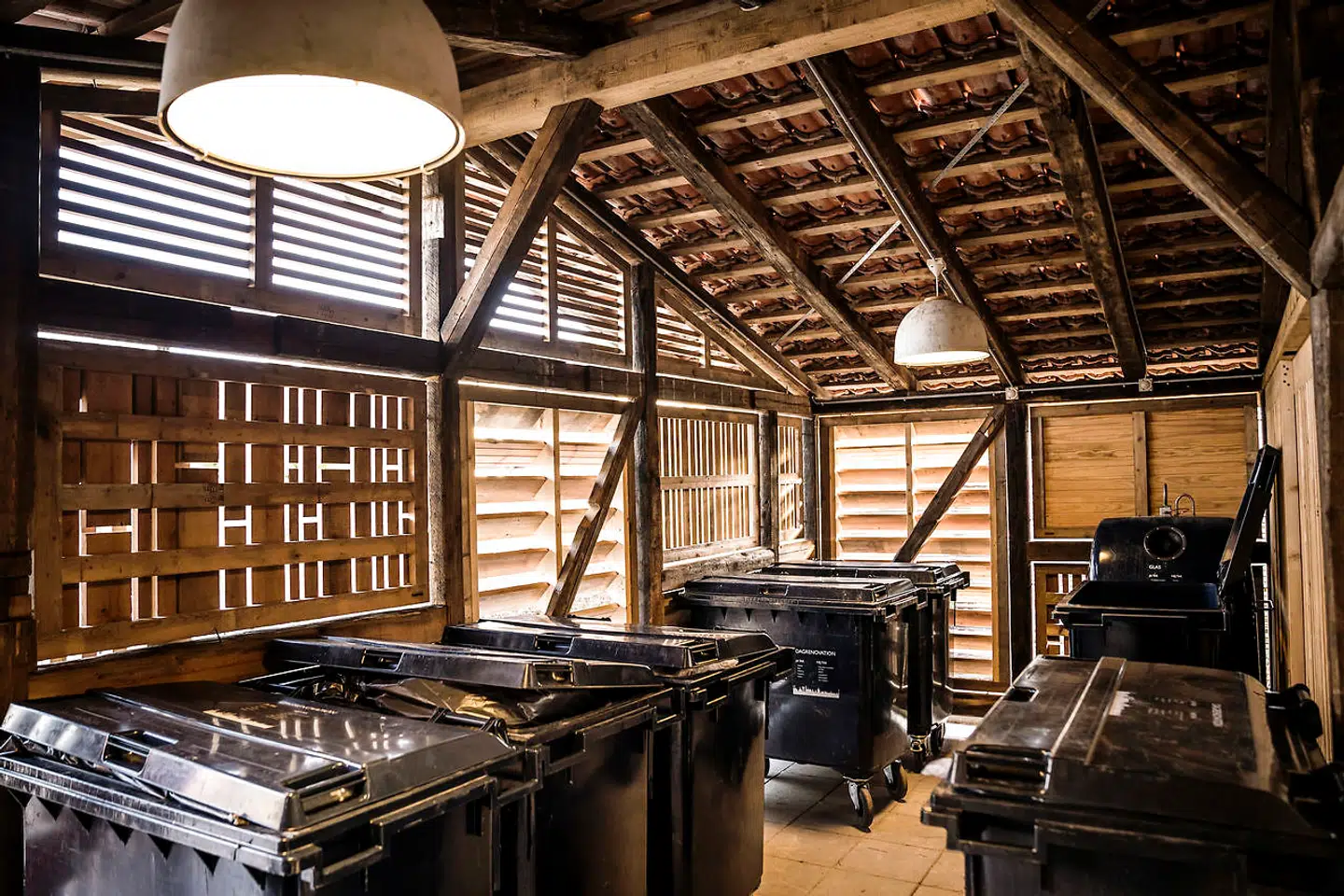 Det bløde filtrerede lys inde i skuret får sammen med de gedigne materialer skolens elever til at ønske, at skuret kunne bruges til andet og mere end affaldscontainere.