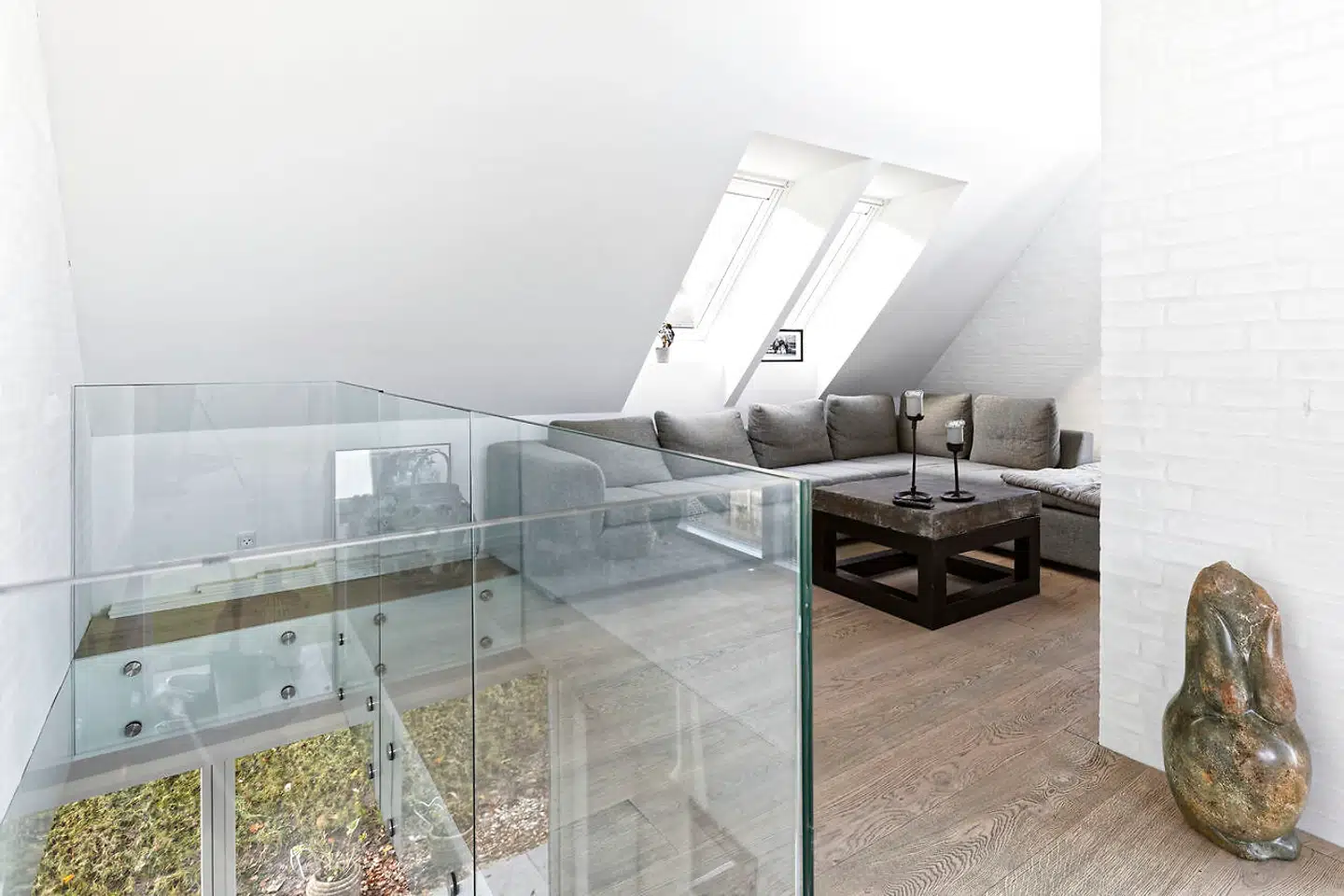 Hjørnesofaen findes ved trappen på første sal. Bordet med en antik kinesisk fortovsflise er købt hos Christiansen & Co. ligesom de antikke jernlysestager.