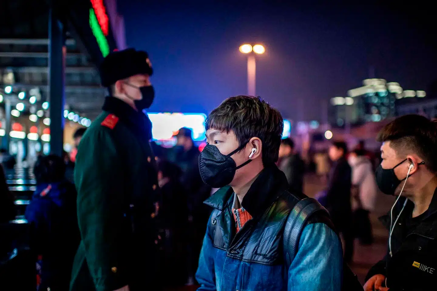 TOPSHOT - People wearing protective masks walk outside Beijing railway station in Beijing on January 22, 2020. - A new virus that has killed nine people, infected hundreds and reached the United States could mutate and spread, China warned on January 22, as authorities urged people to steer clear of the city at the heart of the outbreak. (Photo by NICOLAS ASFOURI / AFP)