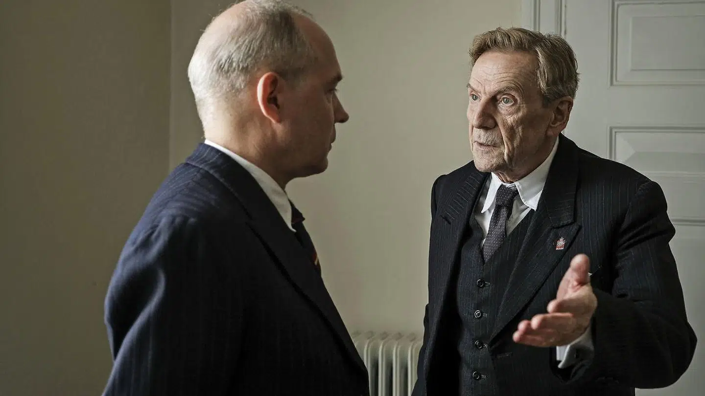 »Virkelighedens udgave af Karl Skov lod den lille kongenål i reversen gøre det ud for det nationale sindelag samtidig med, at han solgte – og solgte ud – til den nazistiske fjende,« skriver Adam Holm i anledning af ny dansk film om besættelsen og samarbejdspolitikken. Til højre på billedet Jesper Christensen, der i »De forbandede år« spiller værnemageren Karl Skov.