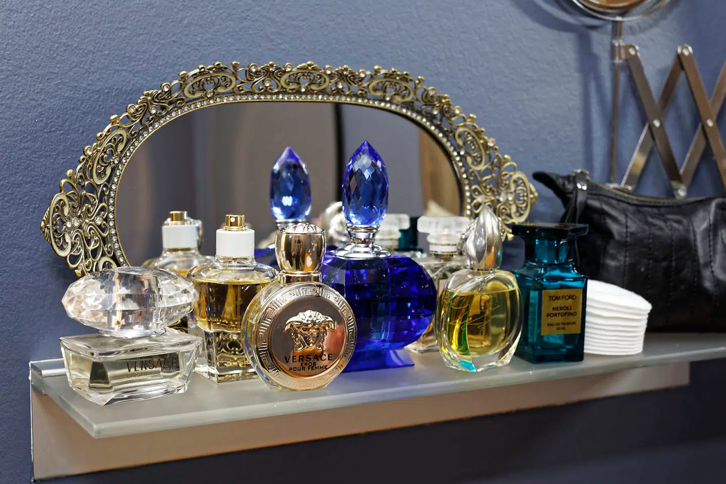 Selv parfumeflakonerne på sminkebordet er holdt i blå og grå nuancer, som går igen i boligen.