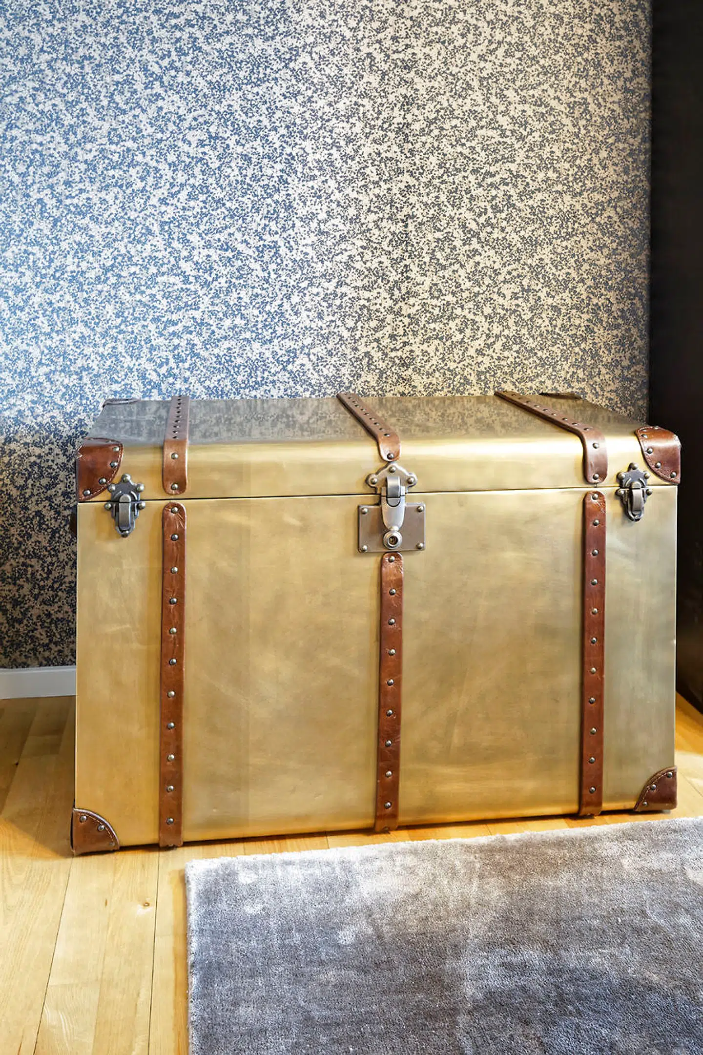 Rejsekufferten bruges til opbevaring i spisestuen. Tapetet er fra Boelskifte Interiør & Design.
