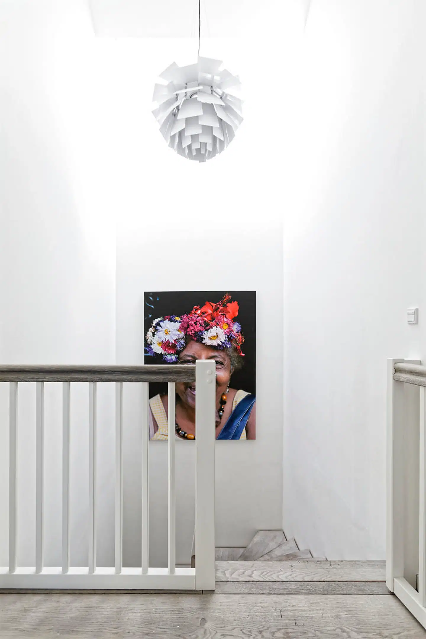 På reposen ved en af husets to trapper hænger et farvestrålende fotografi af en cubansk kvinde med cigar. Billedet er fundet hos BoConcept.