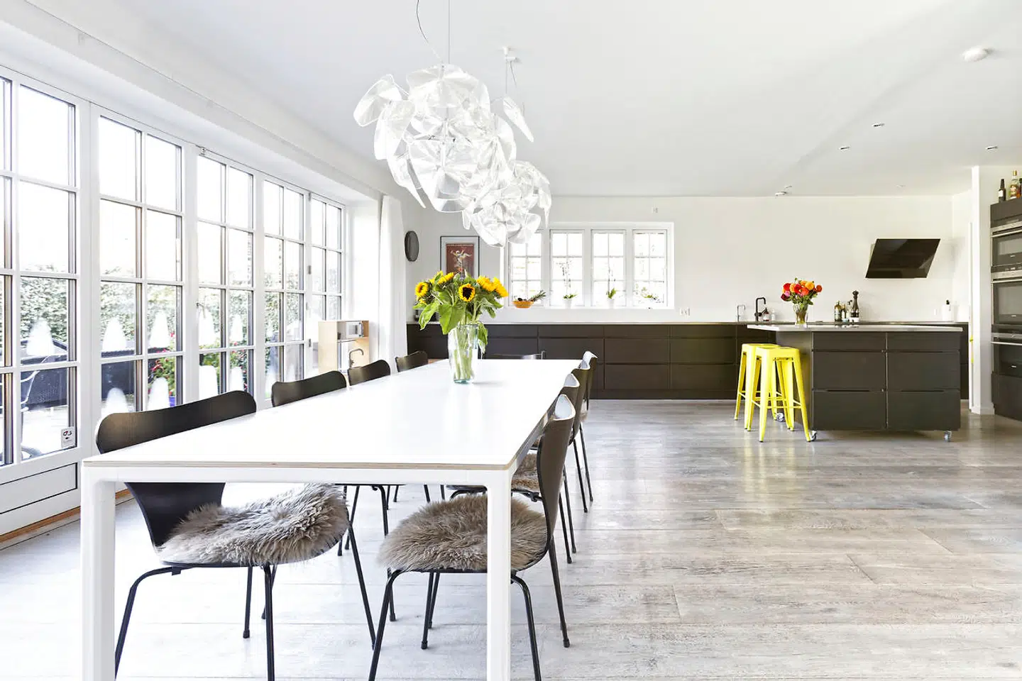 Det lange spisebord fra Hay har afløst et mindre i familiens tidligere lejlighed. Hope-lamperne er fra italienske Luceplan. De gule barstole er fra franske Tolix.