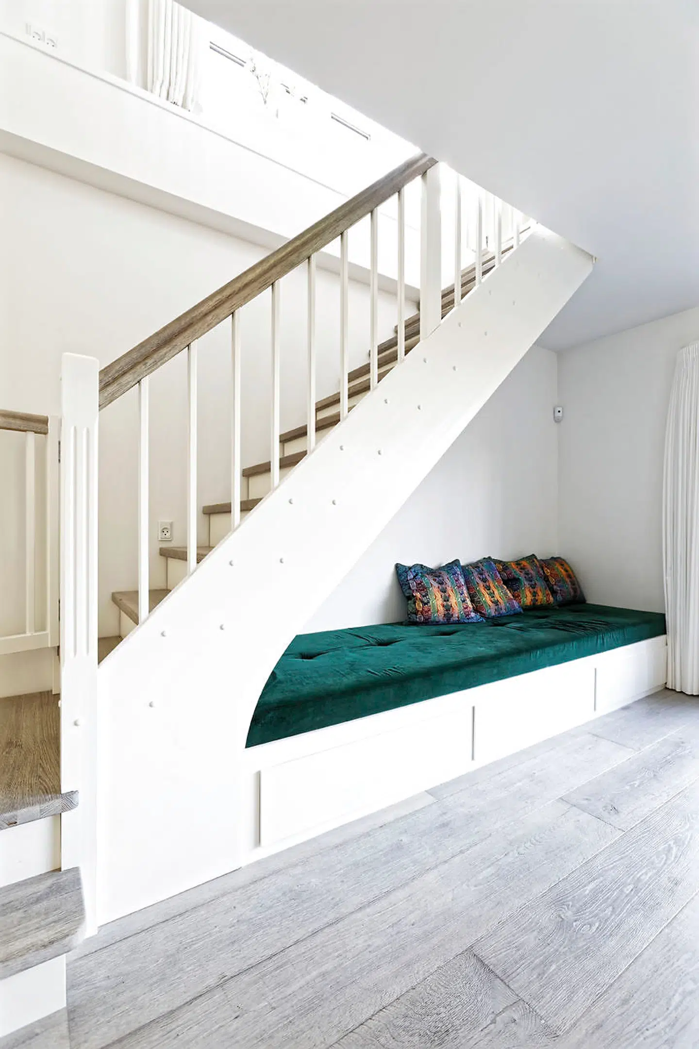 Den indbyggede bænk under trappen har skuffer til opbevaring af legetøj med mere. Puderne er købt på en ferie i Zimbabwe. Karoline boede som barn to år i Mozambique på grund af sin mors arbejde.