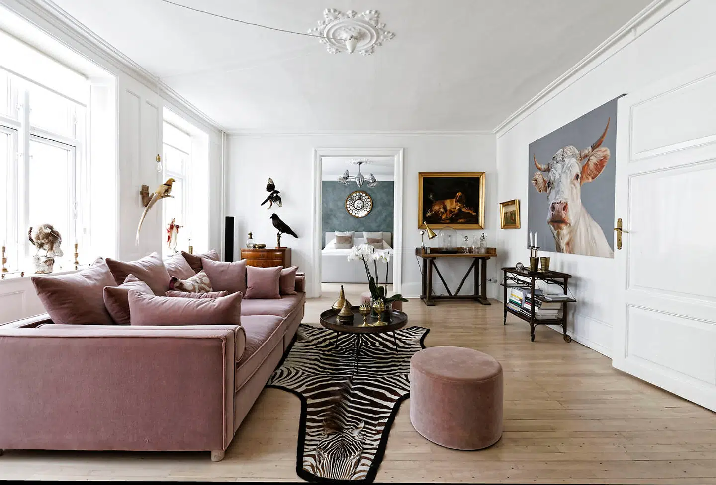 Den rosa veloursofa fra Bolia.com er loungestuens signaturmøbel, som står midt i rummet. Broholmermaleriet hang i farfarens Gentoftevilla. Bordet under er italiensk og forkortet af Marianne Duffield.