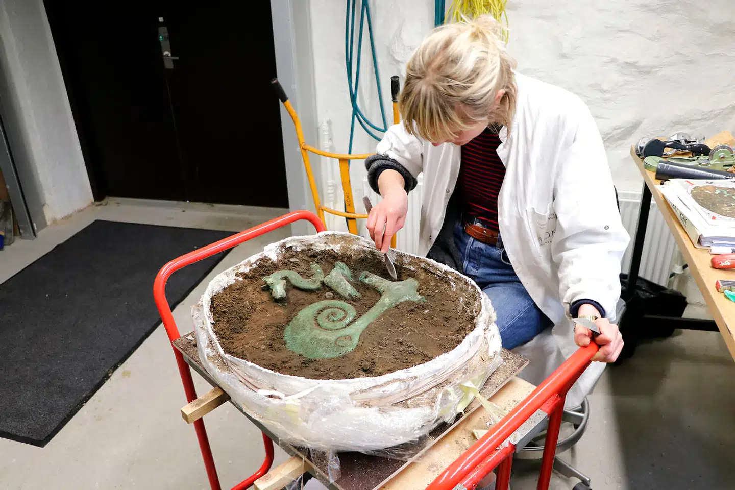 Den ceremonielle bronzeøkse blev pakket i gipsgaze og fragtet til Moesgård Museum, før man omhyggeligt fritlagde genstandene.