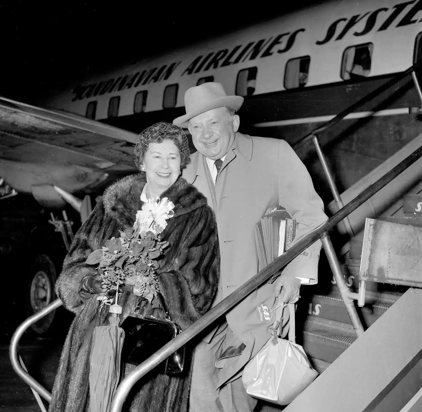 Den dansk-amerikanske skuespiller Jean Hersholt ankommer til København i 1955 sammen med sin frue, Via, der var født i Grenaa. Hersholt døde året efter af cancer.