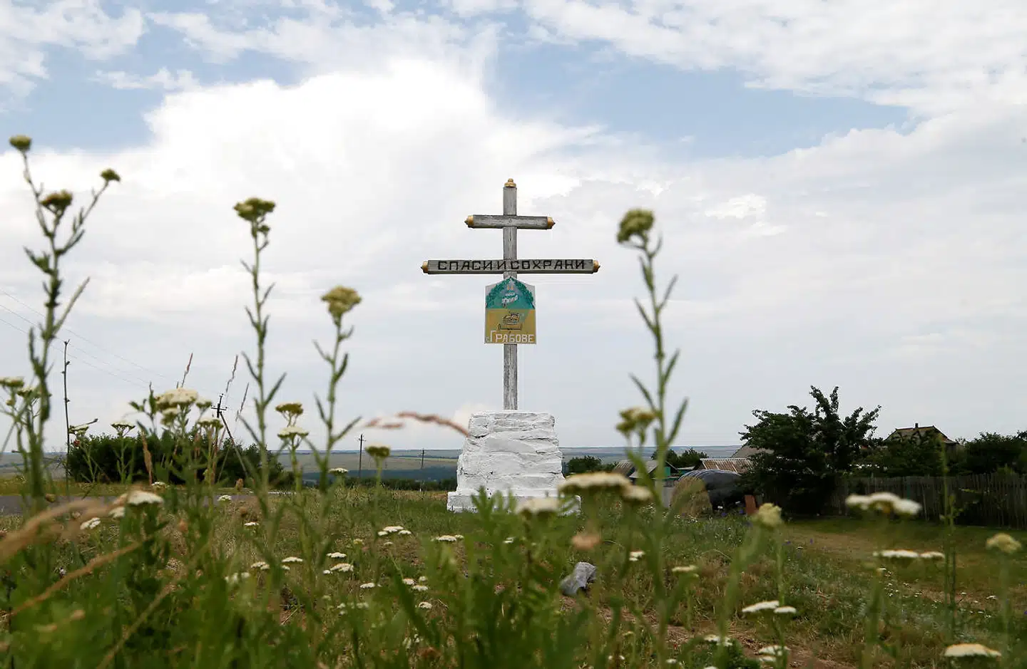 Et kors står ved det sted, hvor Malaysia Airlines MH17 styrtede ned, efter det blev skudt af pro-russiske seperatister i Donetsk, Ukraine i 2014. På korset står der: »Frels og beskyt«.