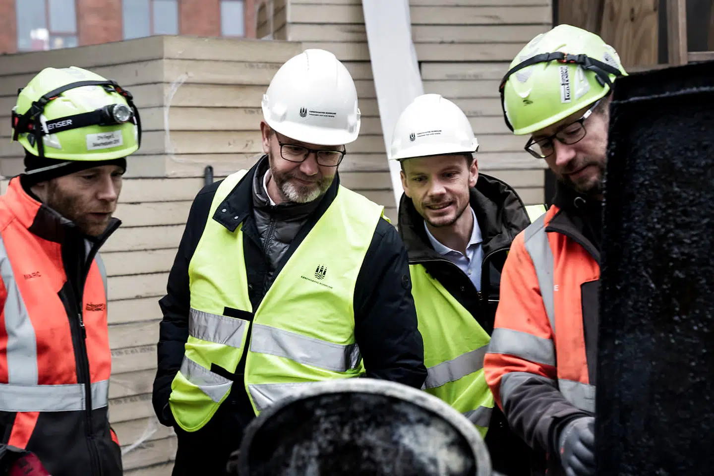 »Vi kan ikke acceptere, at der finder social dumping sted på kommunens byggepladser, som i sidste ende er finansieret af københavnerne,« siger Frank Jensen (S), overborgmester i København (i midten). Han var mandag på besøg på en byggeplads sammen med beskæftigelsesminister Peter Hummelmose (S) (nr. to fra højre).