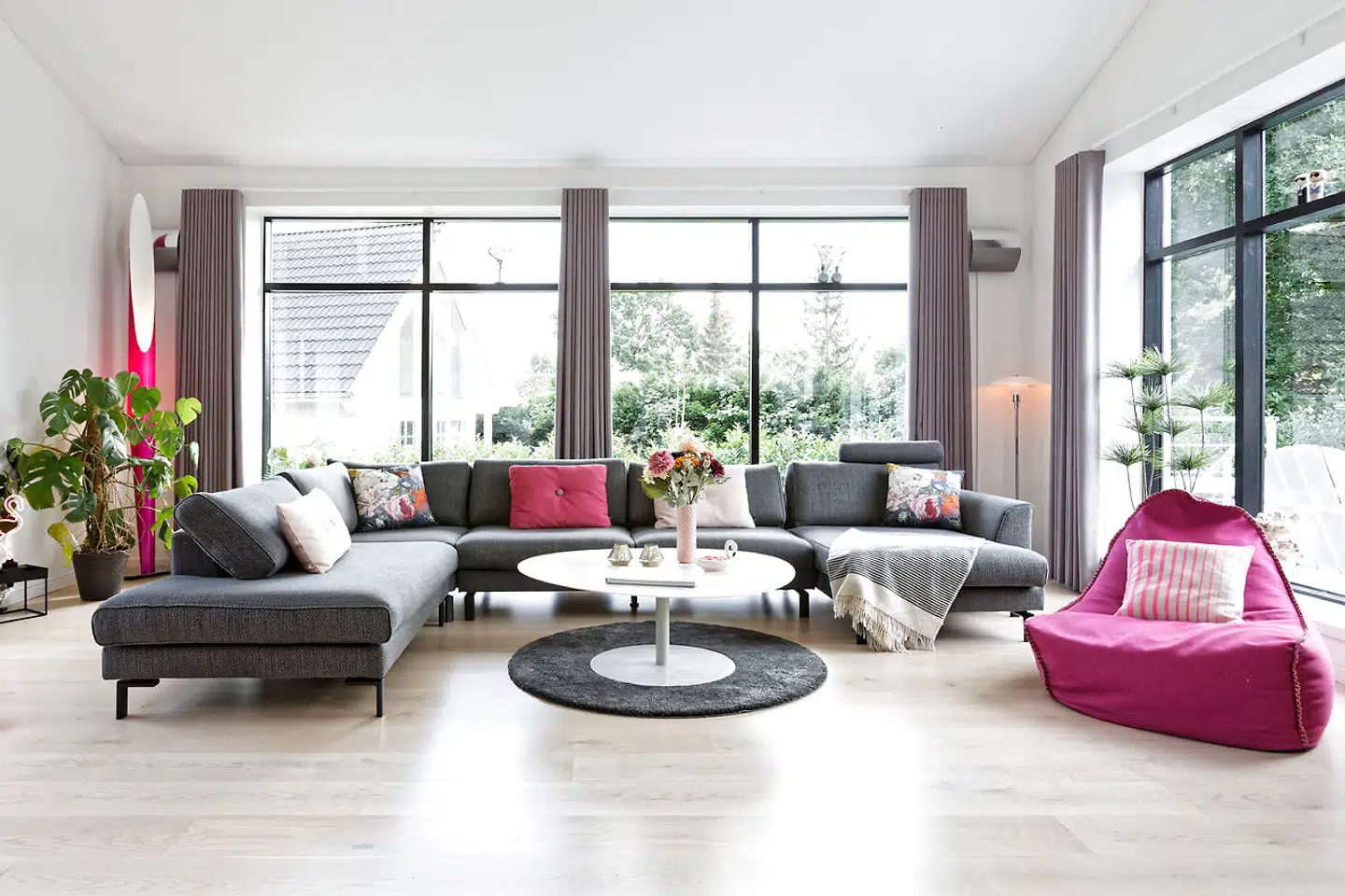 Stuen i en tidligere havestue fra 1985 har de beholdt de oprindelige vinduer og fået nyt gulv af ask. Maria Schøn havde gerne haft en pink eller lyserød sofa. Men en grå sofa er mere praktisk til børn.