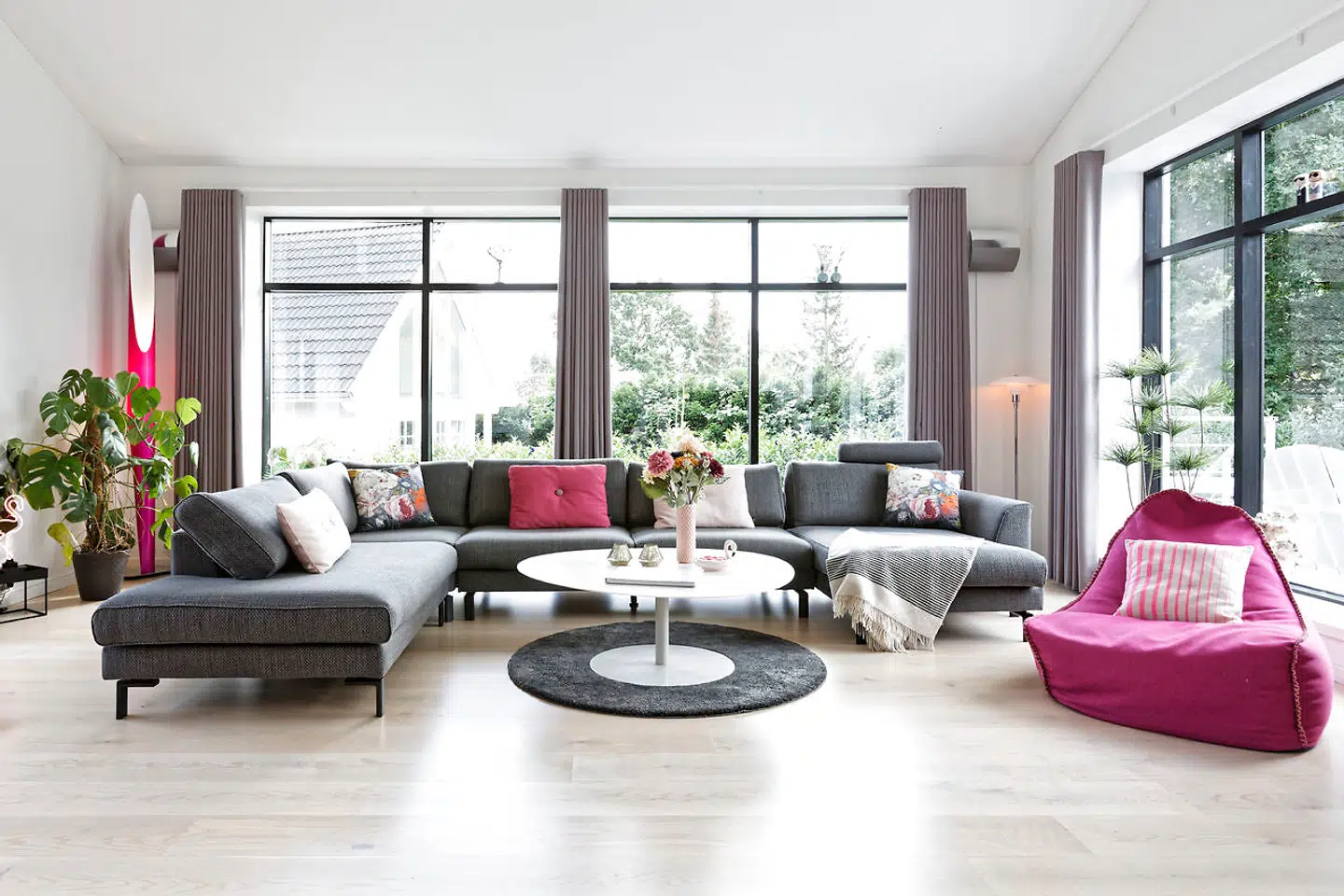 Stuen i en tidligere havestue fra 1985 har de beholdt de oprindelige vinduer og fået nyt gulv af ask. Maria Schøn havde gerne haft en pink eller lyserød sofa. Men en grå sofa er mere praktisk til børn.