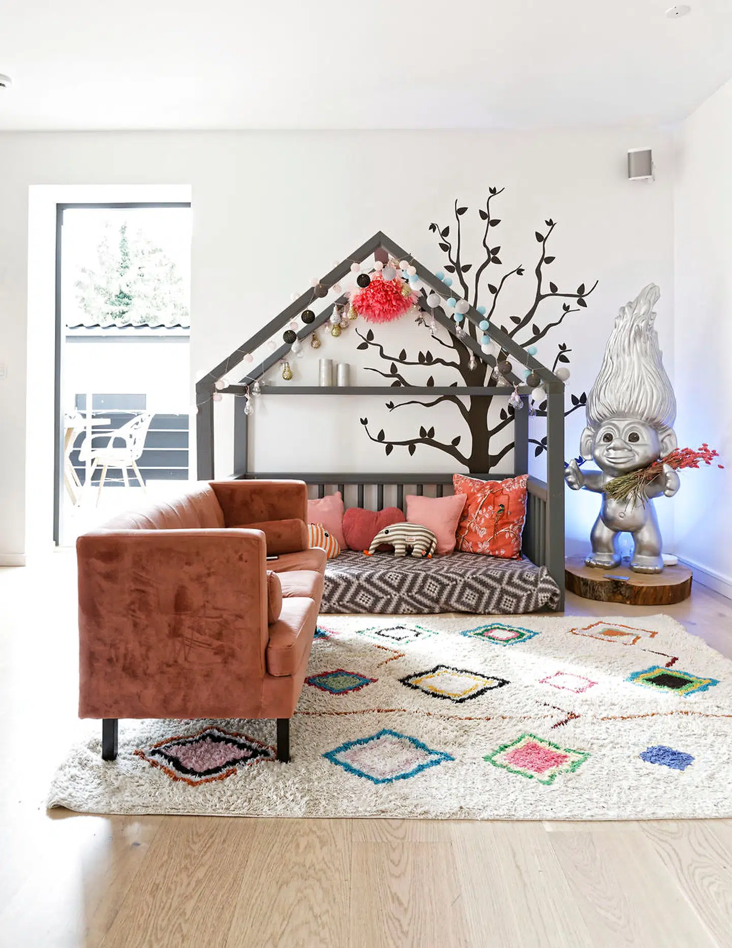 I forstuen har børnene på fire og syv år legeområde, hvor de kan være nær de voksne. Sofaen er fra Jotex, legehuset byget af en tømrer og den store trold af plast er en bryllupsgave.