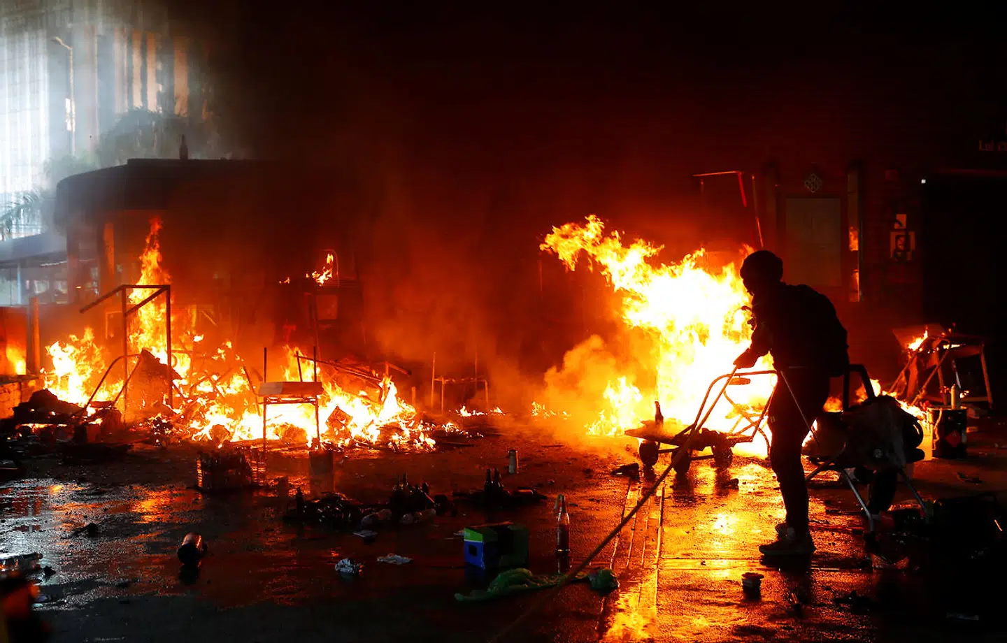 En demonstrant ved Hong Kong Polytechnic University forsøger at slukke en af de brænde, der er opstået i kampene mod politiet.