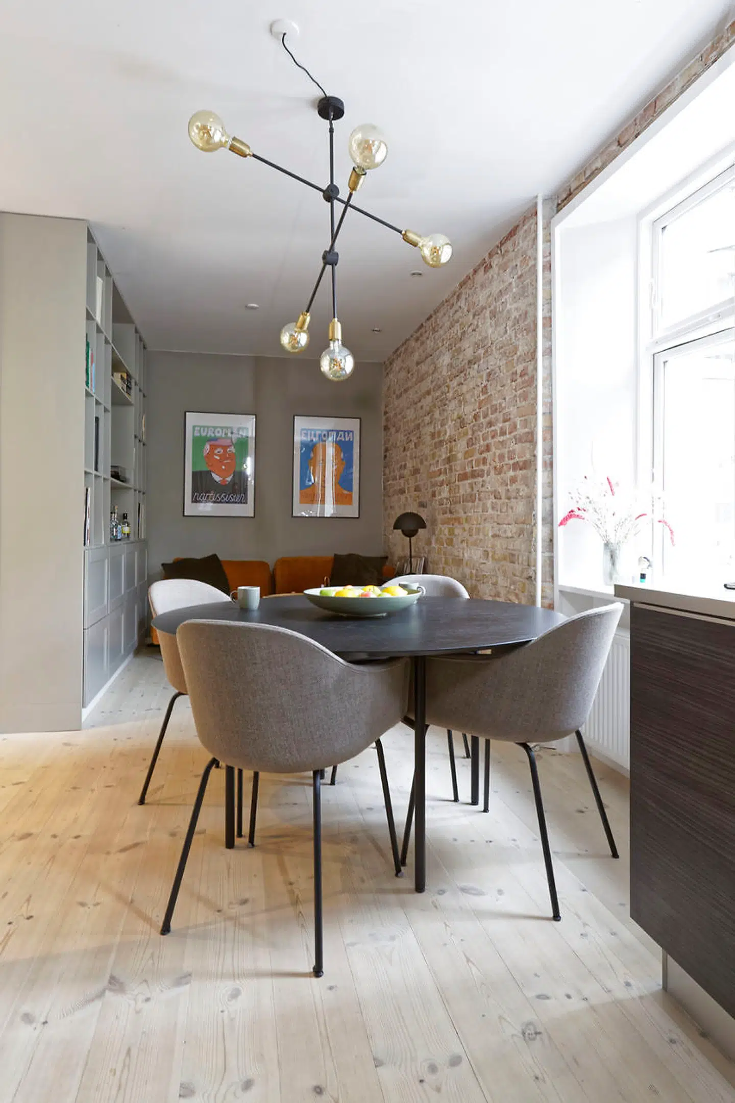 Hvor der før var soveværelse, er der nu stue i forlængelse af køkkenet. Ydervæggens puds er fjernet, mens reolen med skabe er udført af Ikea, Emilie Bjørnskov og hendes far. Sofaen er fra The Sofa Company og de nummererede litografier af kunstneren »Husk mit Navn.«