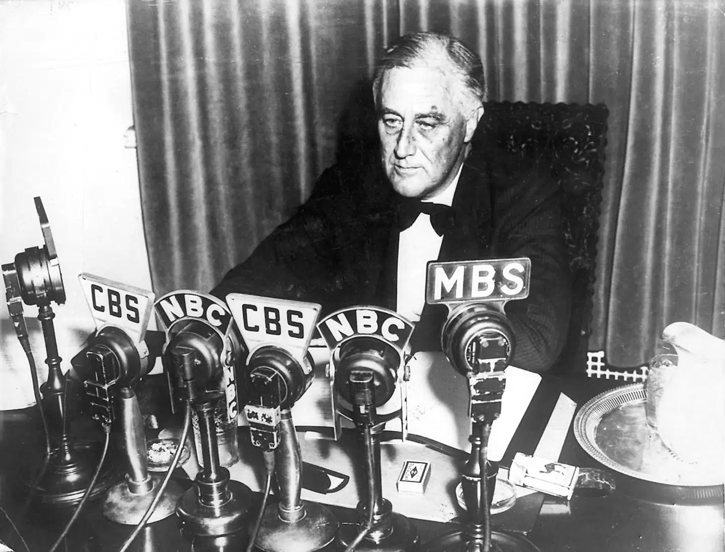 Præsident Franklin Delano Roosevelt holder sin tale fra det Hvide Hus i radioen om USAs neutralitet, efter at England og Frankrig erklærede Tyskland krig i 1939. Seks år forinden havde præsidenten skudt sit omfattende politiske projekt »New Deal« i gang, der pumpede penge ud i det amerikanske samfund for at afhjæpe den økonomiske krise.