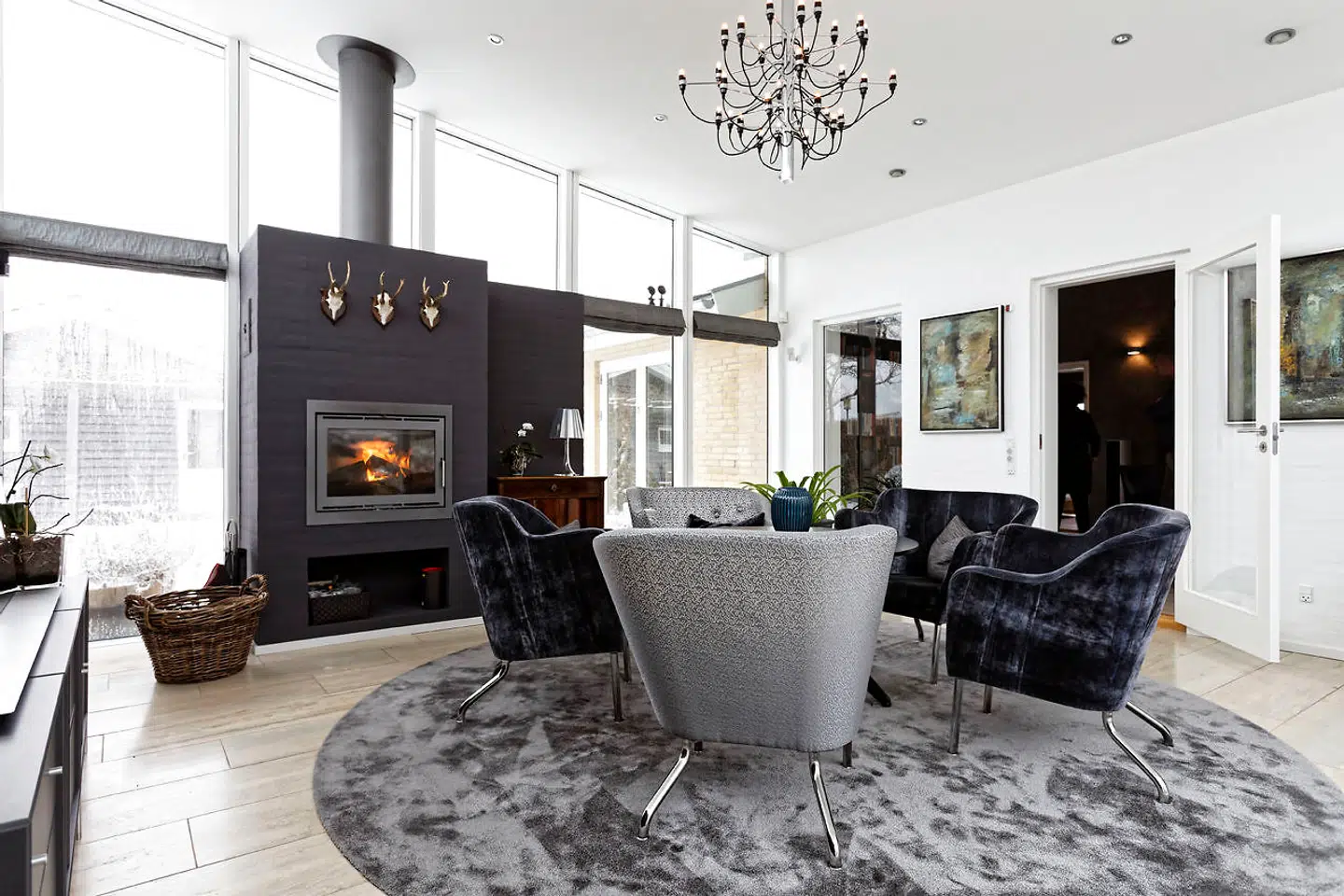 Pejsestuen fra 2008 blev indrettet som loungeområde med pejs og velourbetrukne stole fra svenske Källemo købt hos Boelskifte Interiør & Design. Det runde tæppe er fra Vorwerk og lysekronen er fra Flos. Det spanske Santa & Cole-bord har praktisk hæve-sænke-funktion.