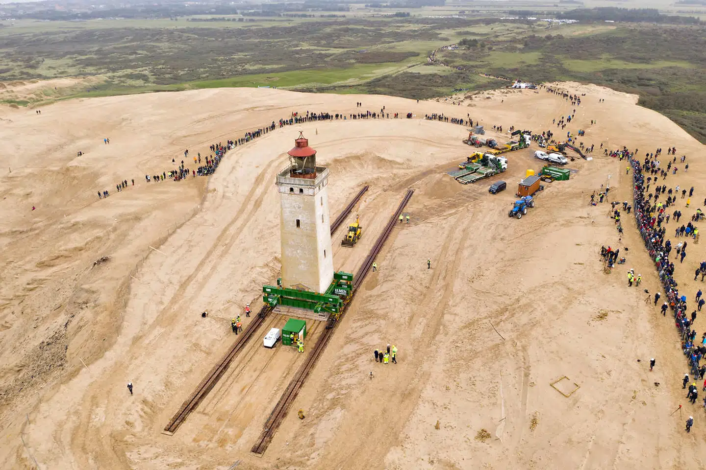 Dronefoto af den spektakulære flytning af Rubjerg Knude Fyr. Fyret var tæt på at ryge i havet, der gravist æder sig ind på kysten, og lokale kræfter flyttede det 70 meter på et sindrigt skinnesystem.